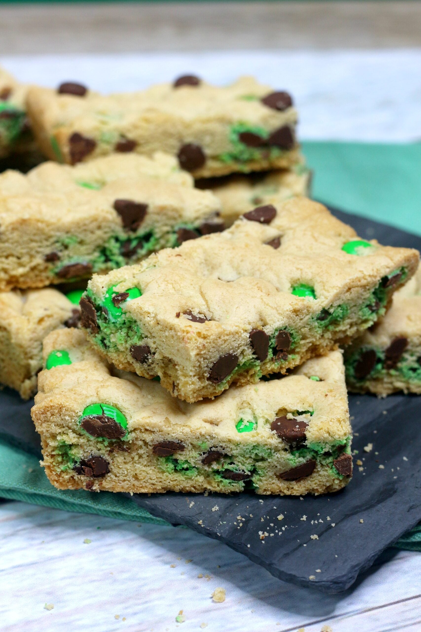 up close image of Saint Patrick's Day Chocolate Chip Cookie Bars on a black serving tray with st paddys day decor