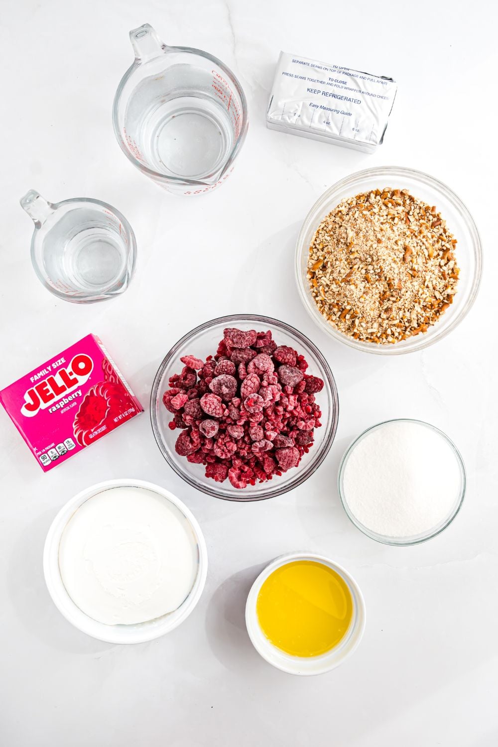 ingredients for Raspberry pretzel Jello salad in single serve bowls on the table all around