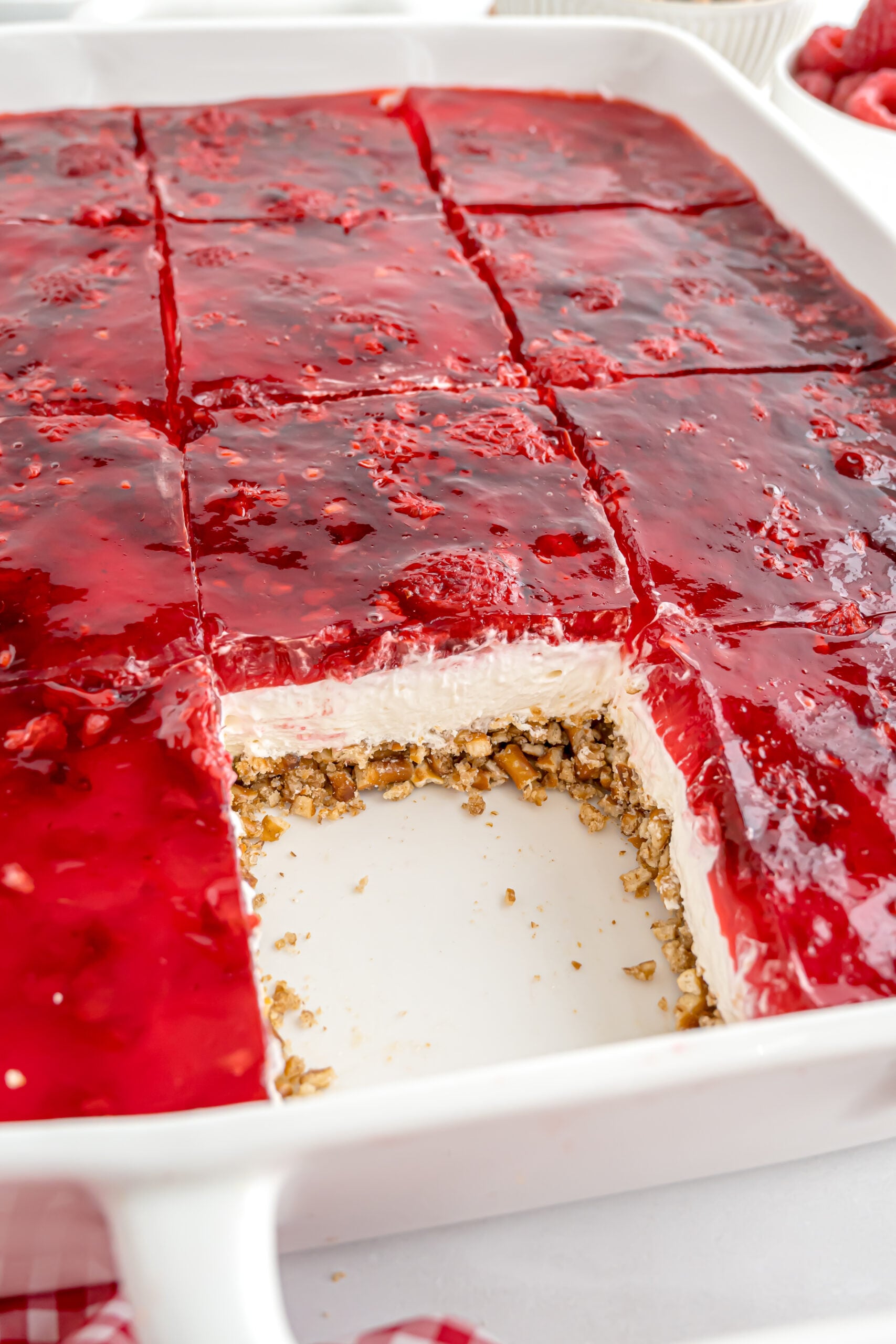 Raspberry Pretzel Salad in a casserole pan with a slice taken out of it