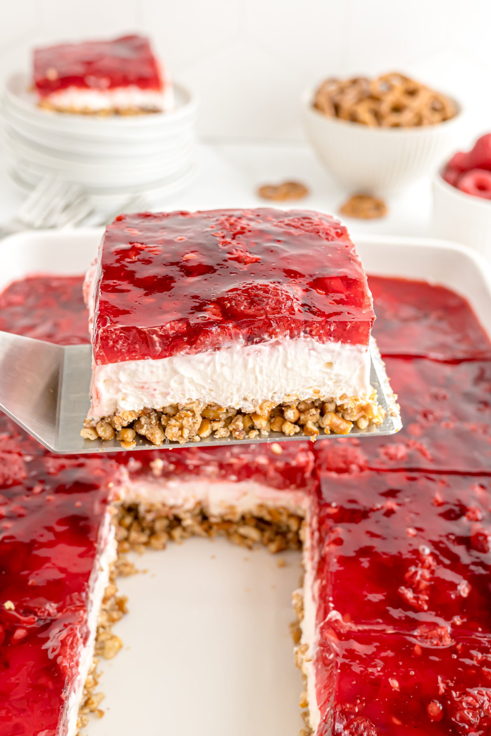 slice of Raspberry Pretzel Salad being lifted up from the baking pan