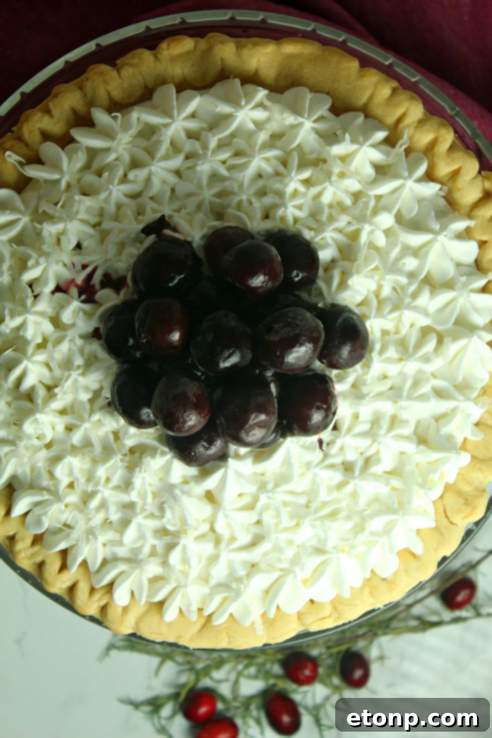 The entire White Christmas Pie, showcasing its golden baked crust, fluffy white filling, and vibrant cherry topping, elegantly presented on a festive platter. Perfect for holiday gatherings.
