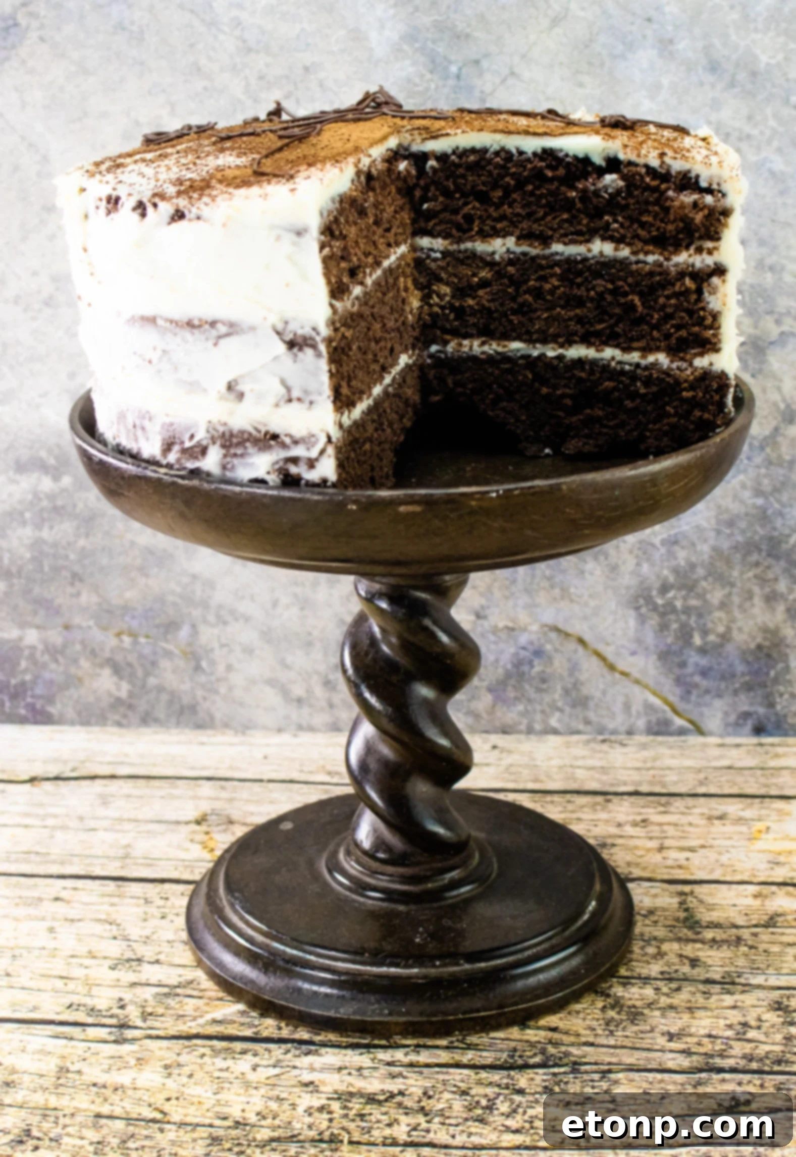 A close-up of the smooth, rich Kahlua Buttercream frosting being spread over the chocolate cake layers.