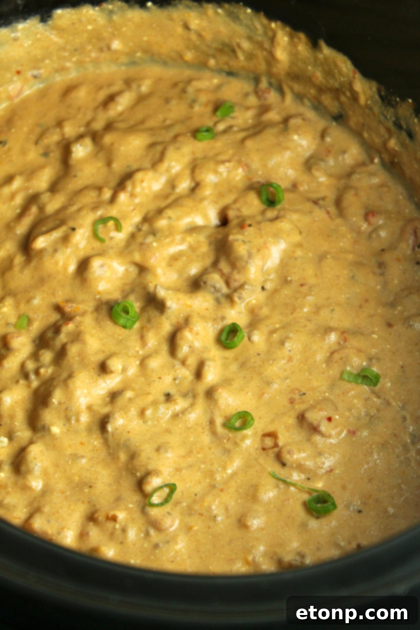 A large bowl of Slow Cooker Taco Dip surrounded by various dippers and toppings