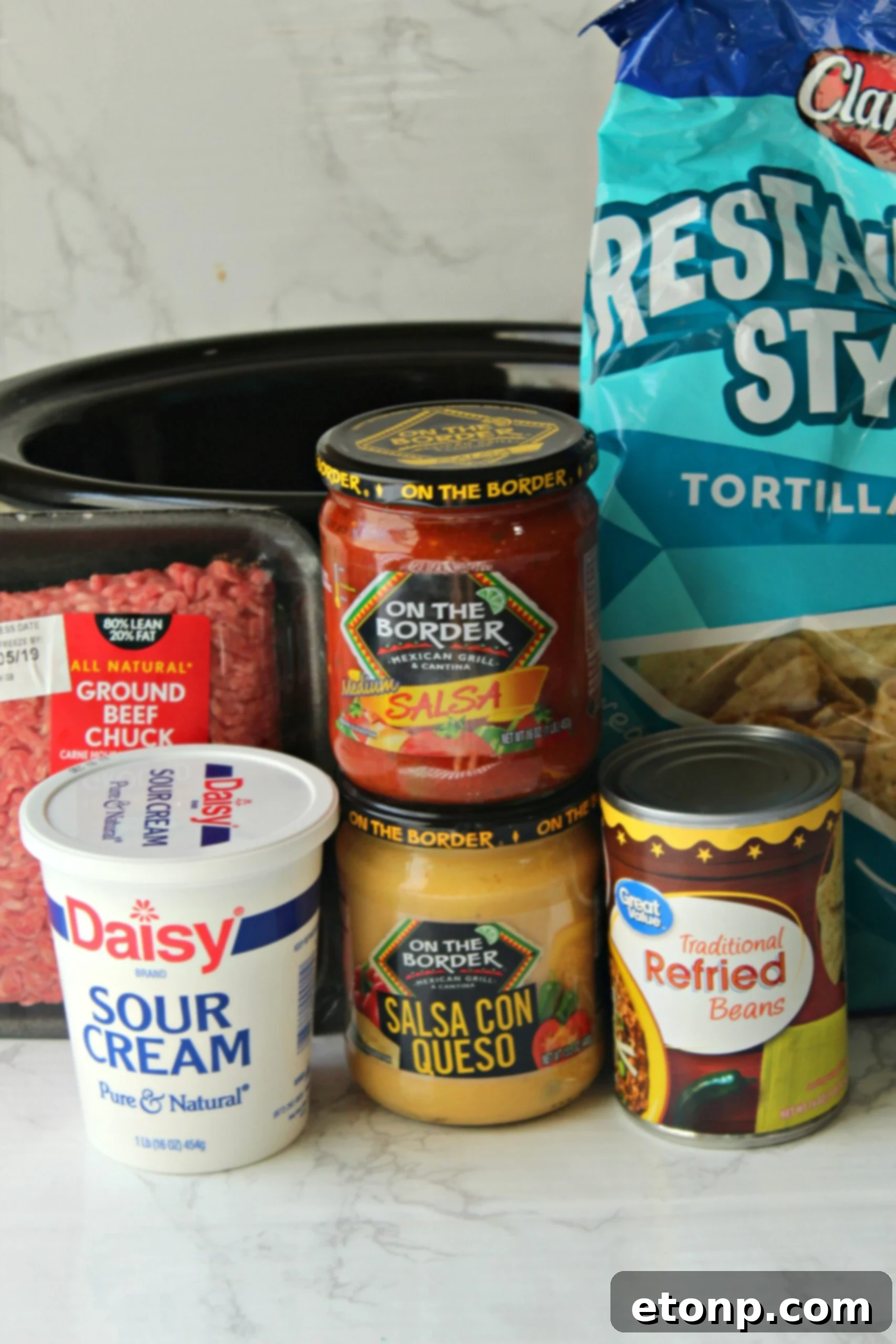 Another mouth-watering shot of Slow Cooker Taco Dip in a pot, garnished and ready