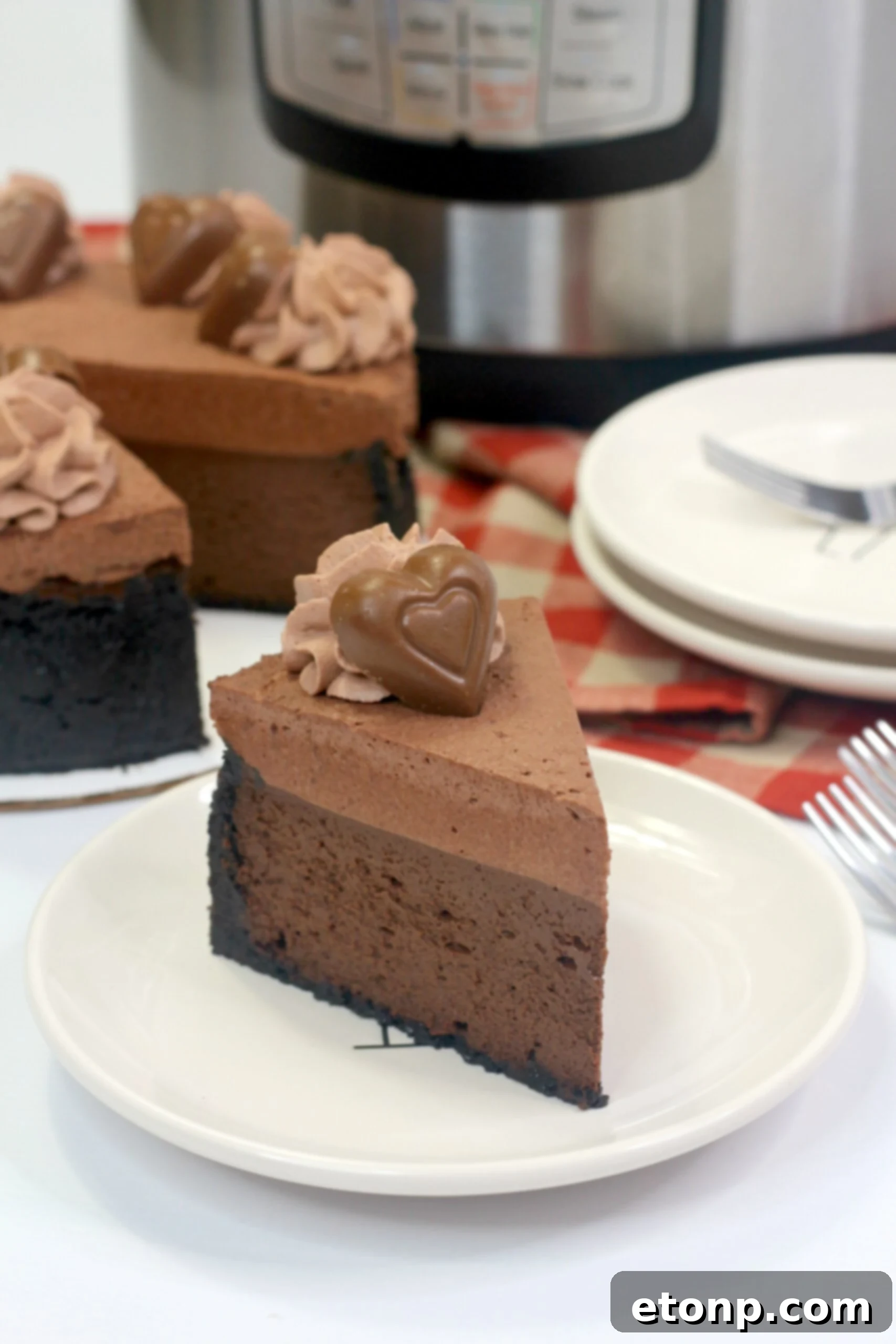 A beautifully decorated Triple Chocolate Godiva Cheesecake with chocolate shavings and candy
