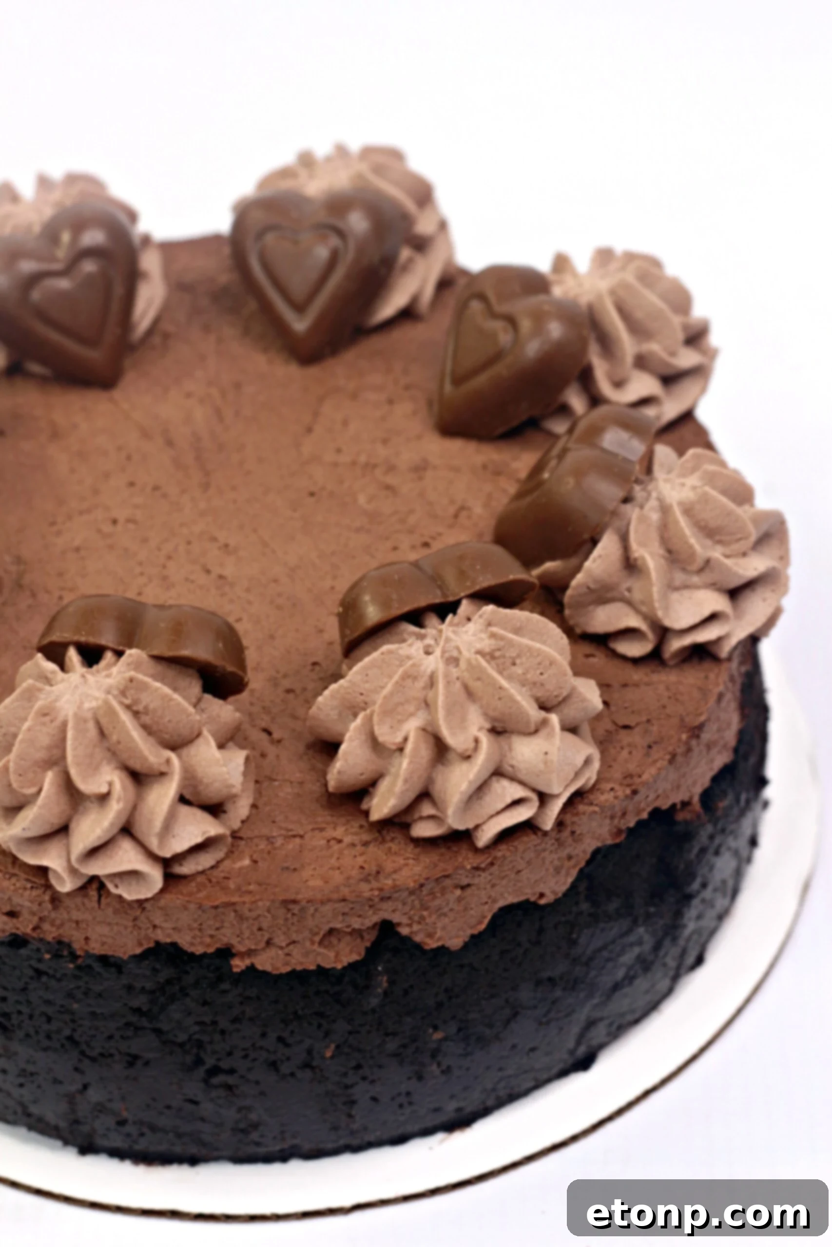 A whole Triple Chocolate Godiva Cheesecake adorned with Valentine's Day chocolate hearts
