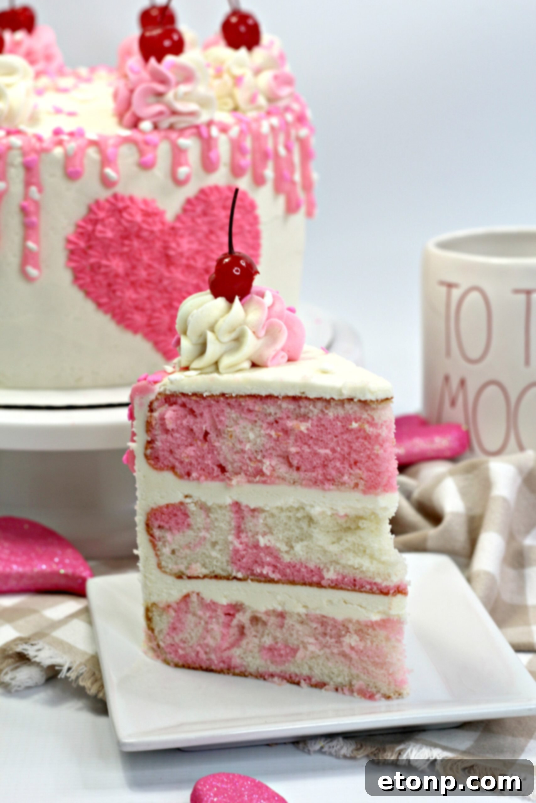 A slice of Valentine's Day Love Cake showing the vibrant pink and white layers and creamy frosting.