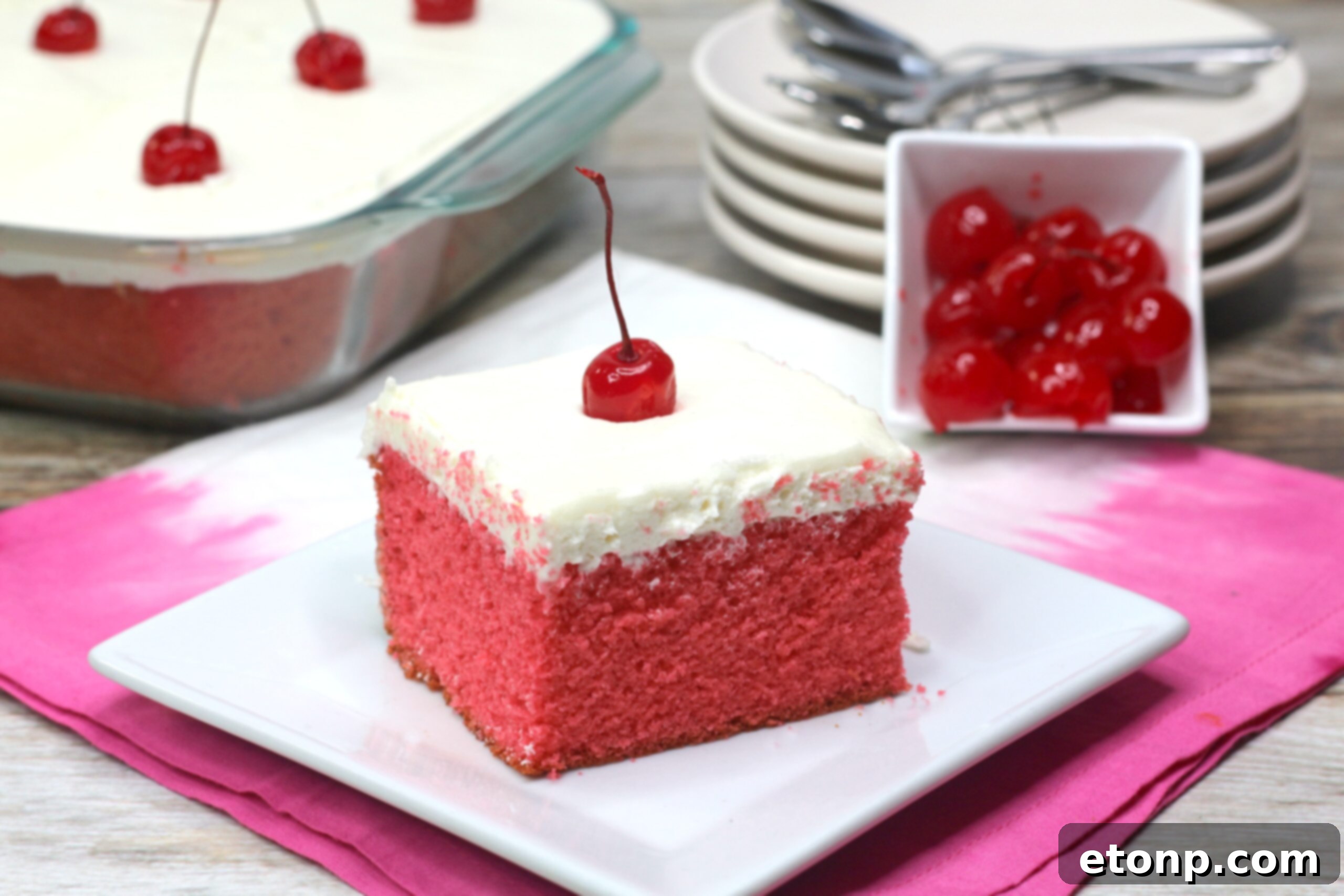 A close-up shot of the Very Cherry Cake, highlighting the smooth, creamy vanilla buttercream and the delicate pink hue of the cake itself.