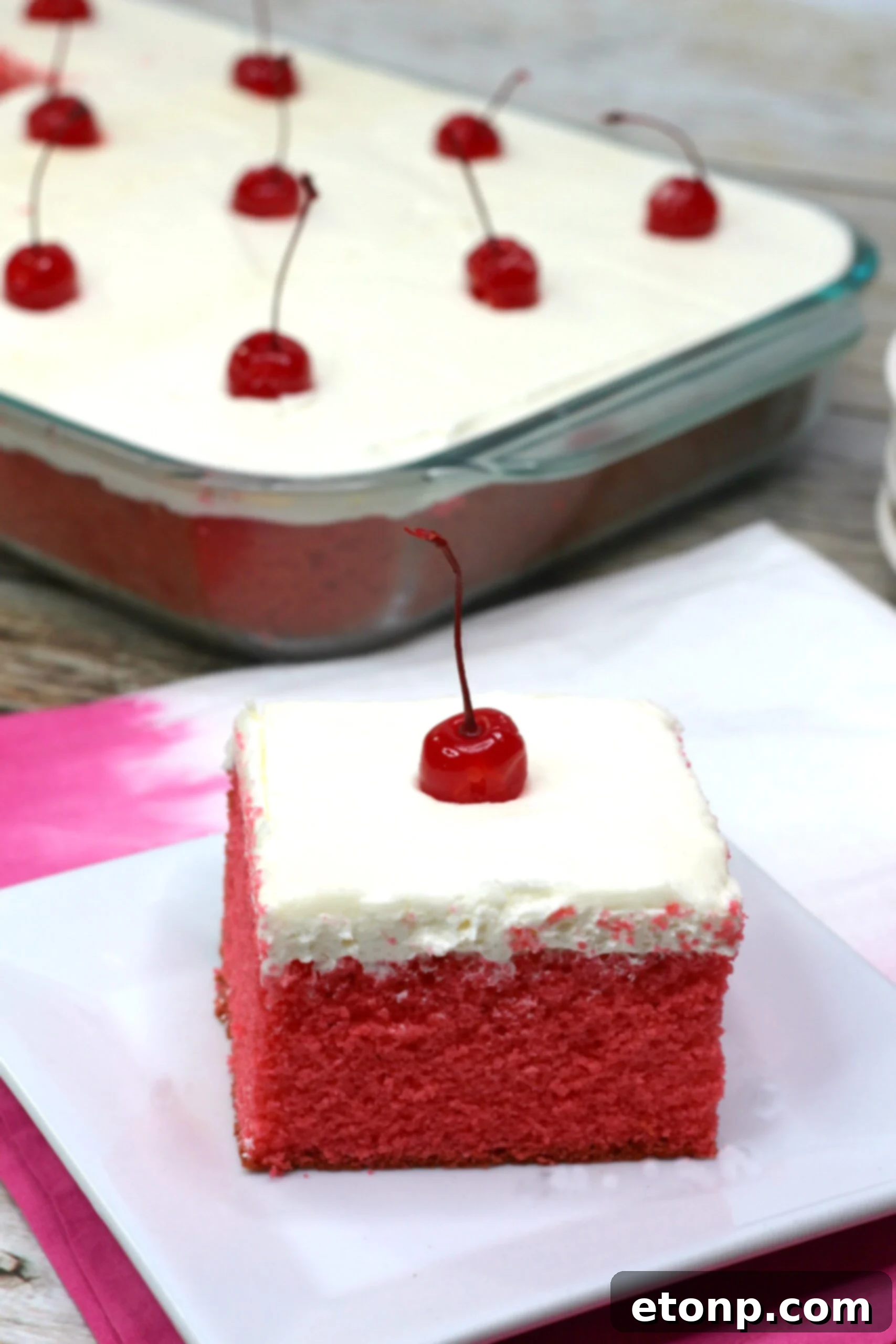 A close-up of the Very Cherry Cake, showcasing the fluffy texture of the vanilla buttercream and the glossy surface of the cake.