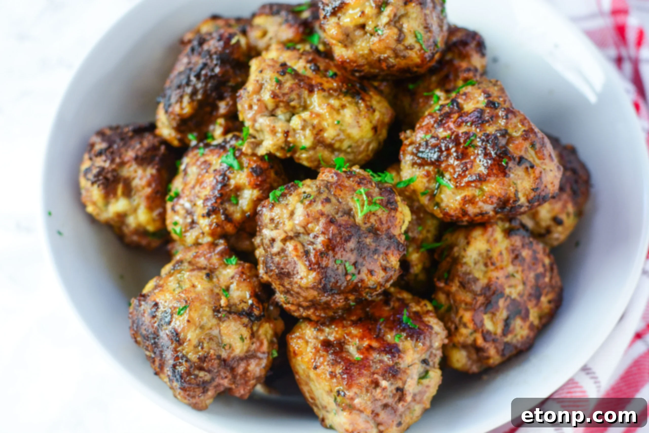 Grandma's Baked Italian Meatballs 8 A close-up shot of a single perfectly browned Italian meatball, showcasing its tender texture.