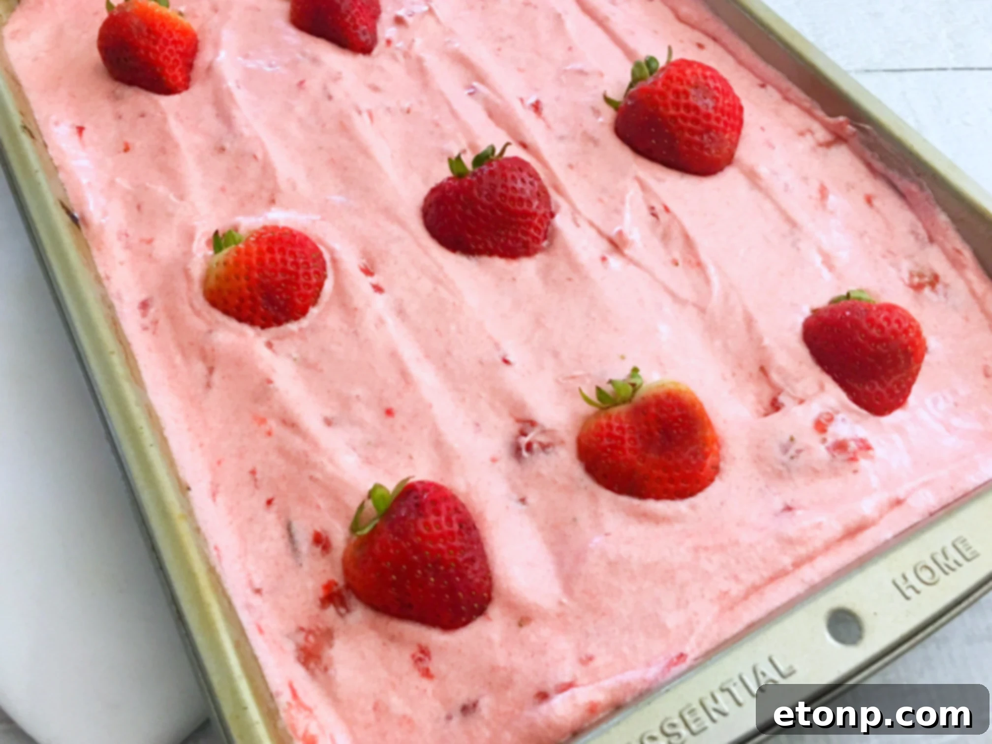 Close-up of the homemade strawberry buttercream frosting, highlighting its smooth texture and light pink color, ready for application.