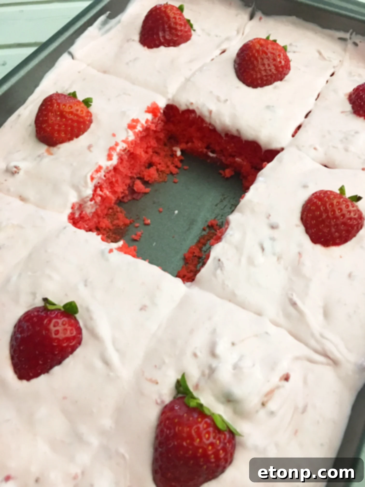Top-down view of the Strawberry Jello Cake garnished with fresh strawberry halves, highlighting its appealing presentation.