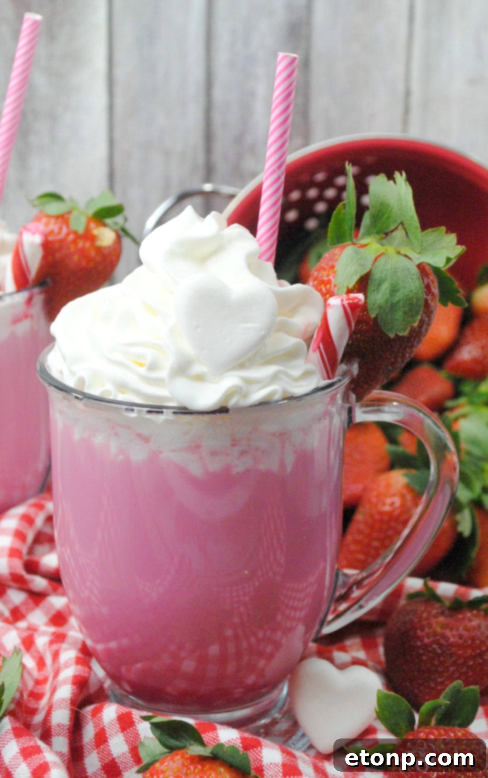 Two mugs of Pink Velvet Hot Chocolate, garnished with heart-shaped marshmallows and sprinkles, perfect for sharing