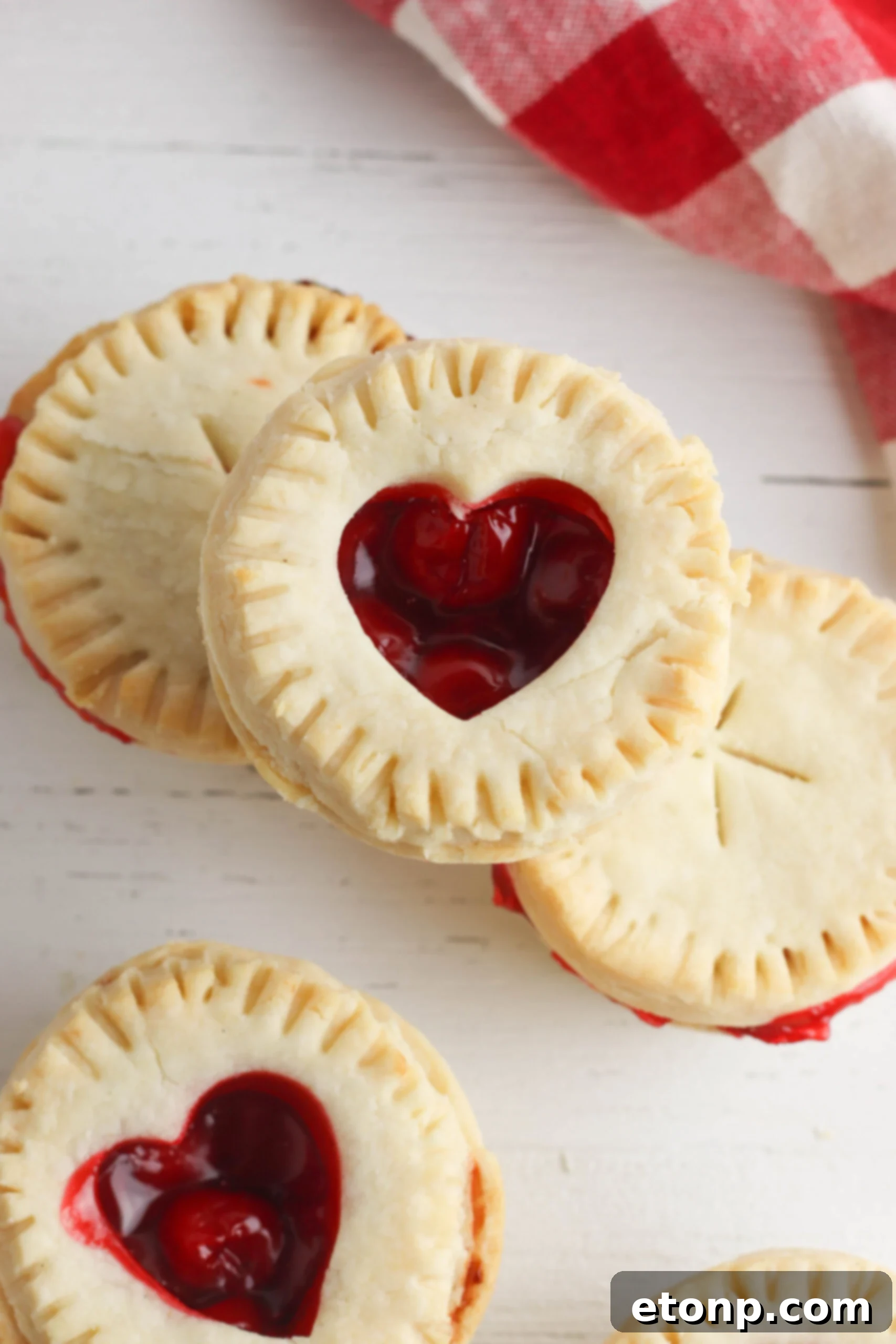 Close-up of a mini cherry pie, showcasing its flaky crust and glistening cherry filling