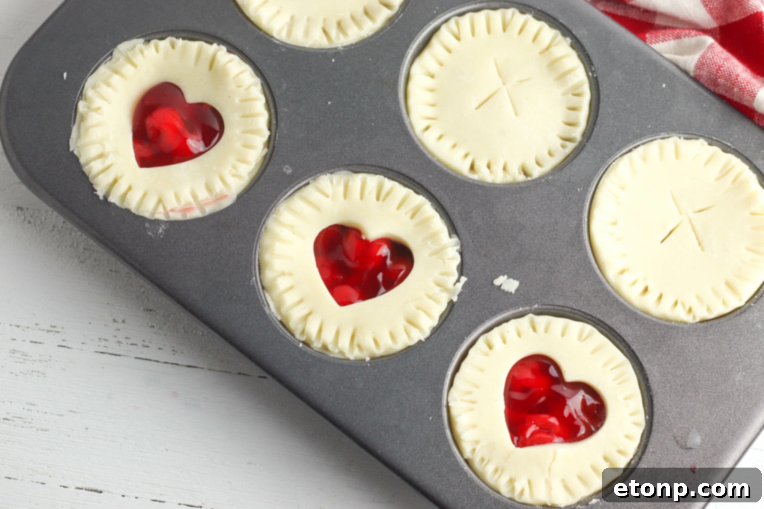 A charming arrangement of several mini cherry pies resting on a wire cooling rack, ready to be enjoyed