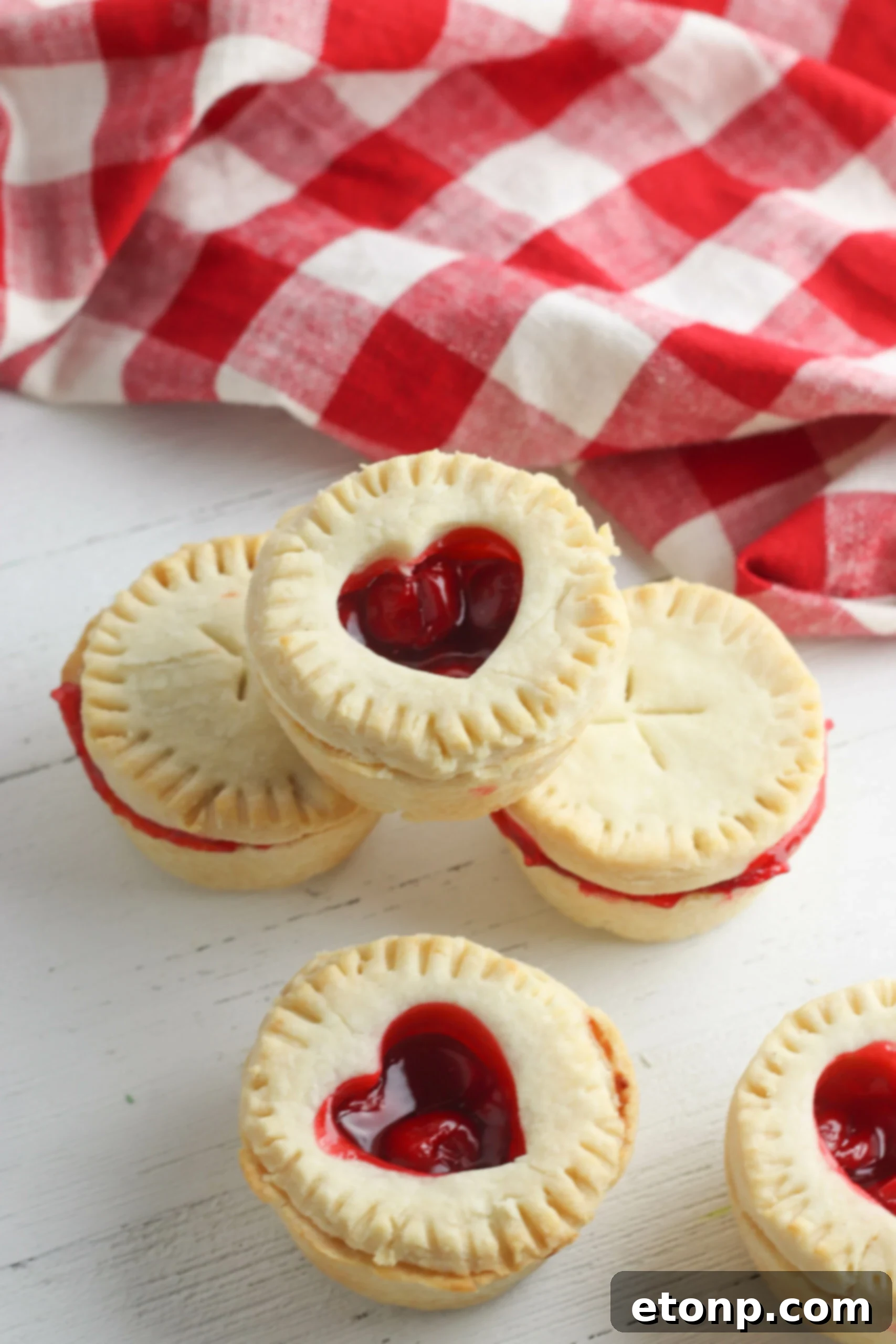 Mini cherry pies with beautifully crafted lattice tops, arranged on a baking sheet, ready for the oven