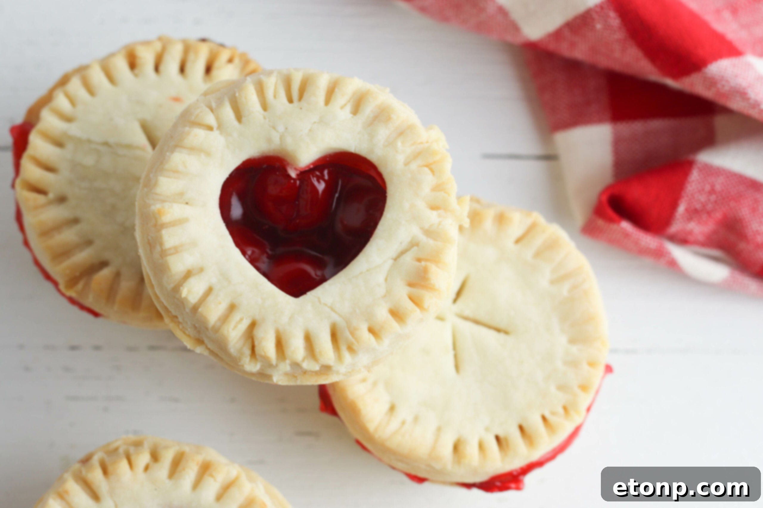Close-up of a single perfectly baked mini cherry pie, showcasing its rich golden-brown crust