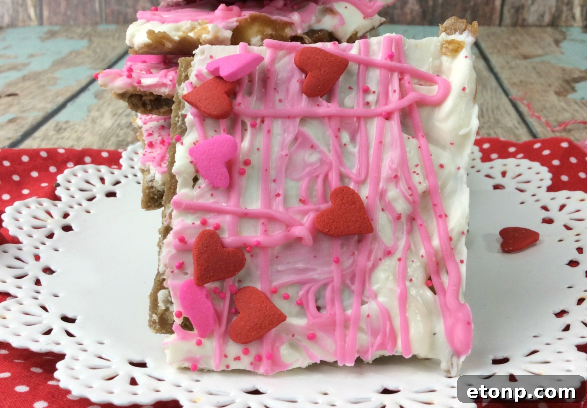 A wider shot of a tray of Valentine's Day Crack, showcasing the pink and white layers and various heart sprinkles.