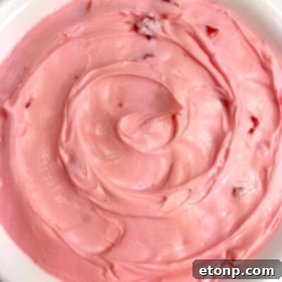 Fresh strawberry buttercream frosting in a bowl.