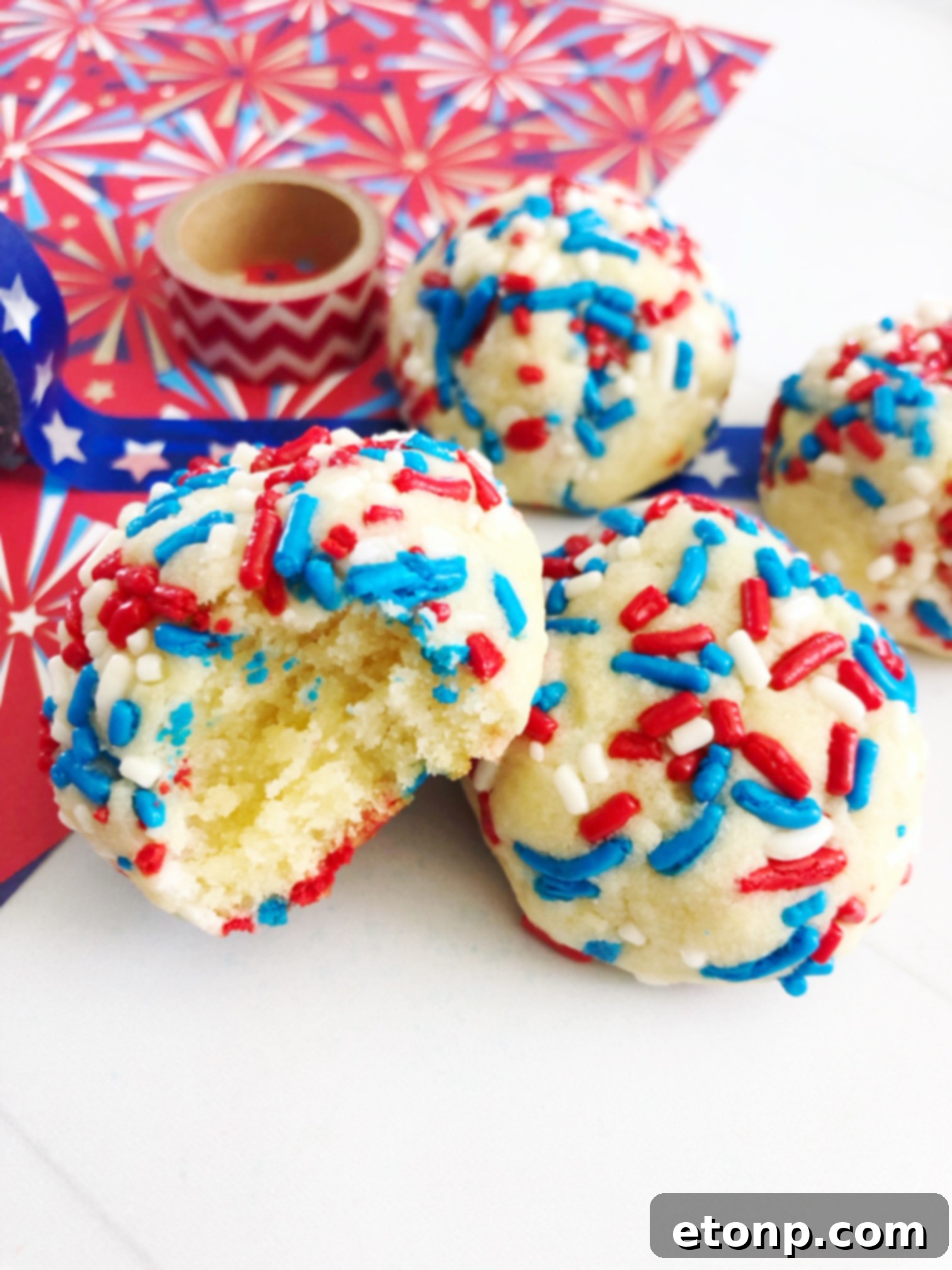 Close-up of freshly baked Butter Drop Sprinkle Cookies, vibrant with colorful sprinkles, arranged on a cooling rack.