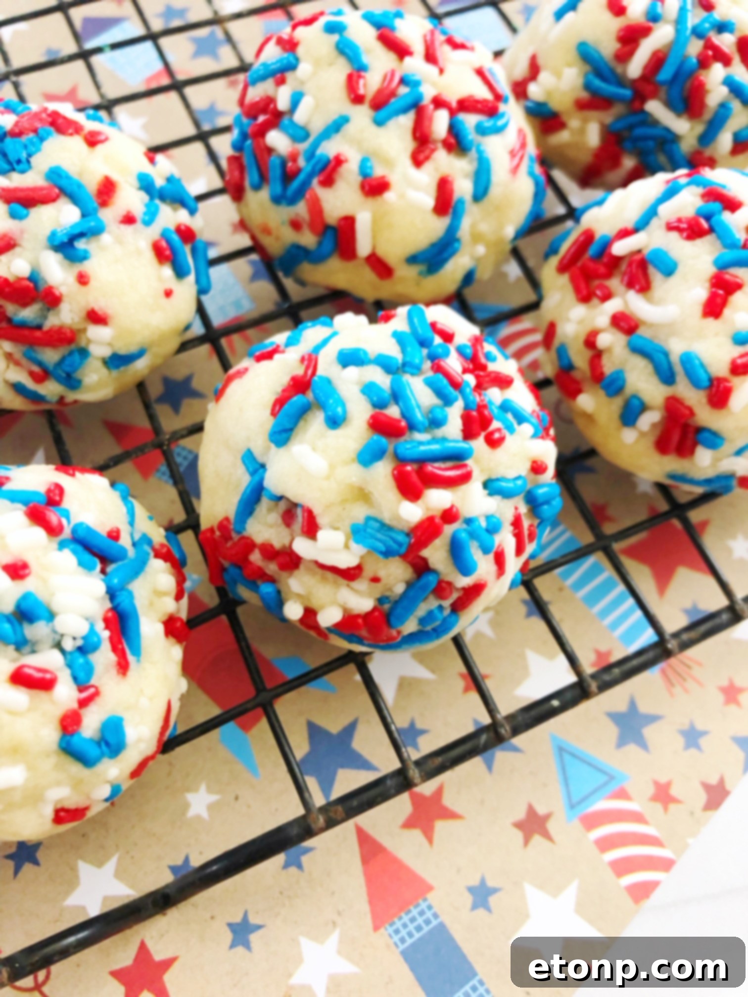 A plate piled high with golden-brown Butter Drop Sprinkle Cookies, showing their soft texture and generous sprinkle coating.
