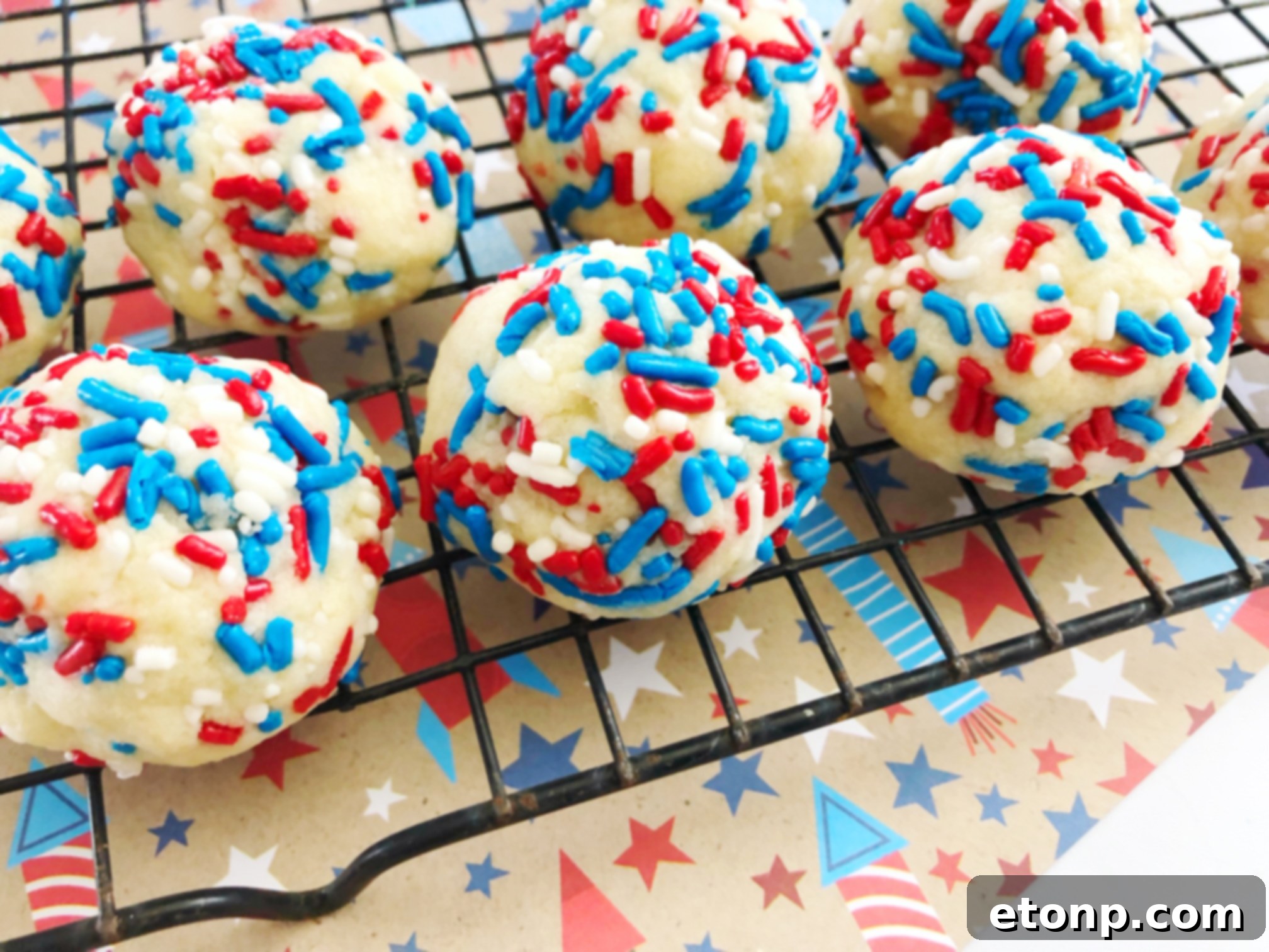 A close-up of a single Butter Drop Sprinkle Cookie, showcasing its delicate texture and colorful sprinkles, ready to be enjoyed.