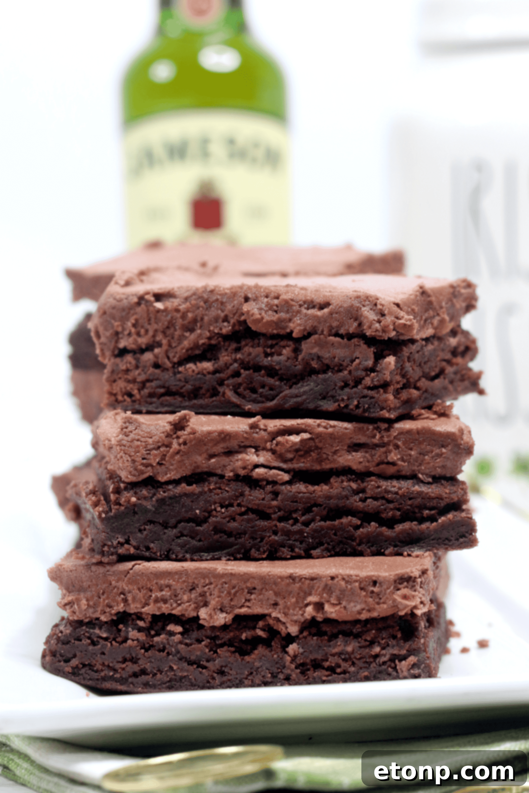 Another enticing shot of a stack of Irish whiskey brownies, highlighting the rich frosting and festive spirit.