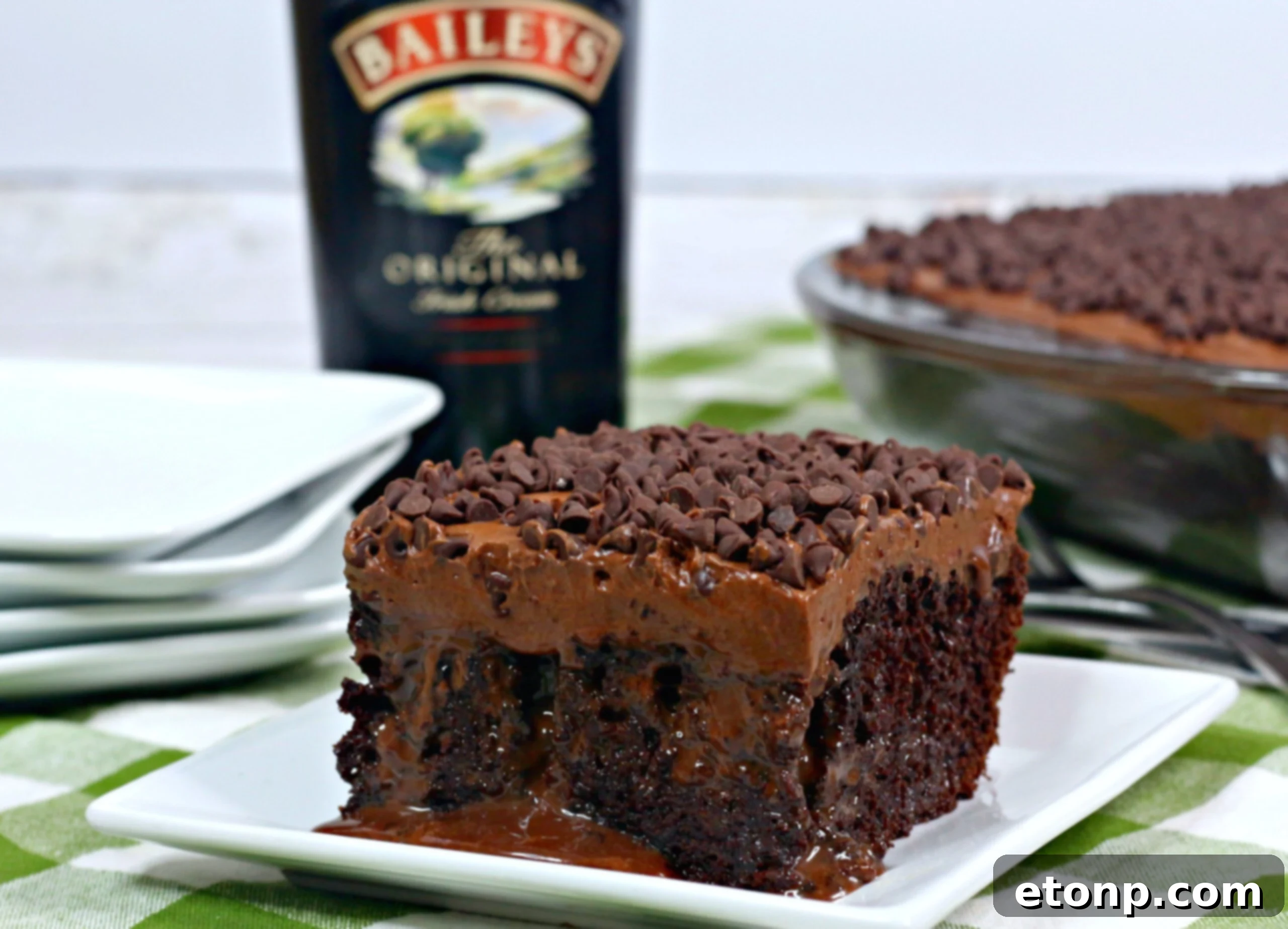 Whole Baileys Irish Cream Chocolate Cake on a white ceramic stand, garnished with chocolate shavings