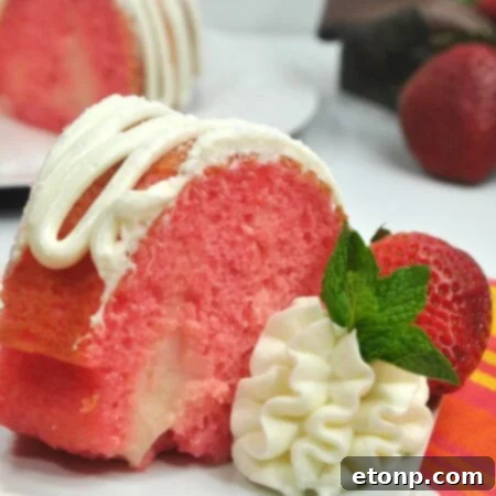 A beautifully decorated Strawberries & Cream Bundt Cake, topped with creamy frosting and fresh berries, ready to be served.