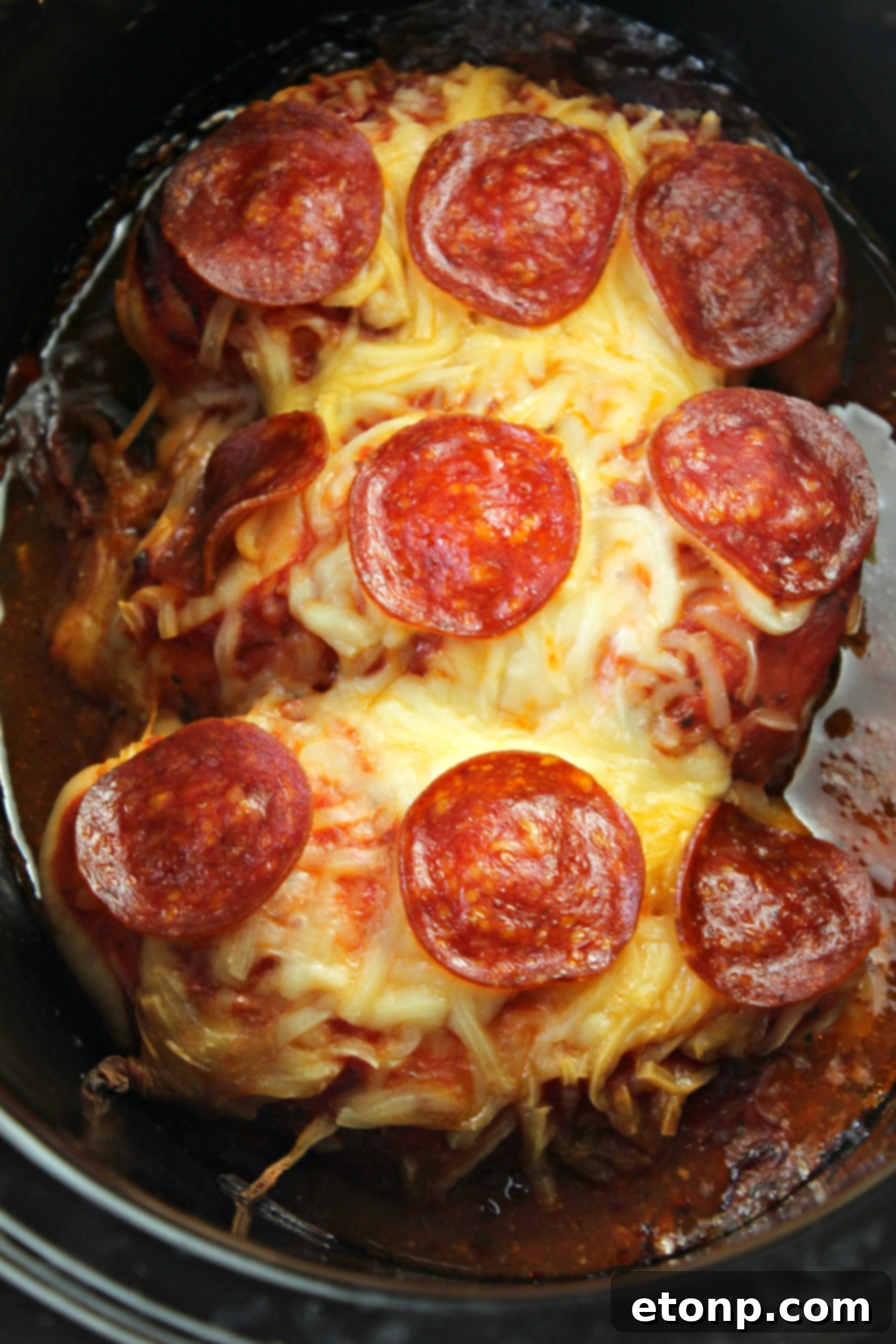 Cooked Slow Cooker Pizza Chicken with various toppings