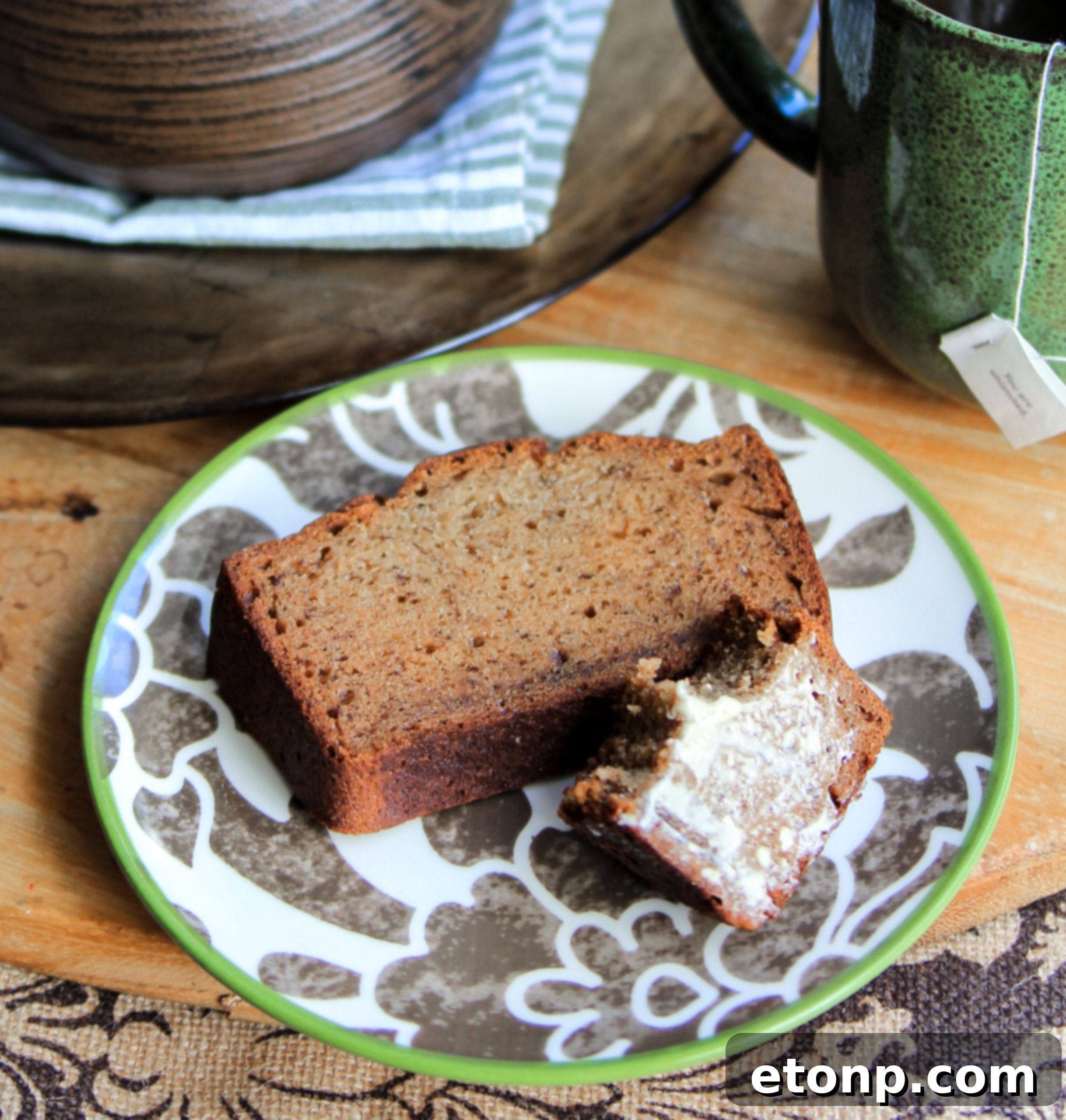 A single slice of warm banana bread, generously slathered with butter, ready to be enjoyed.