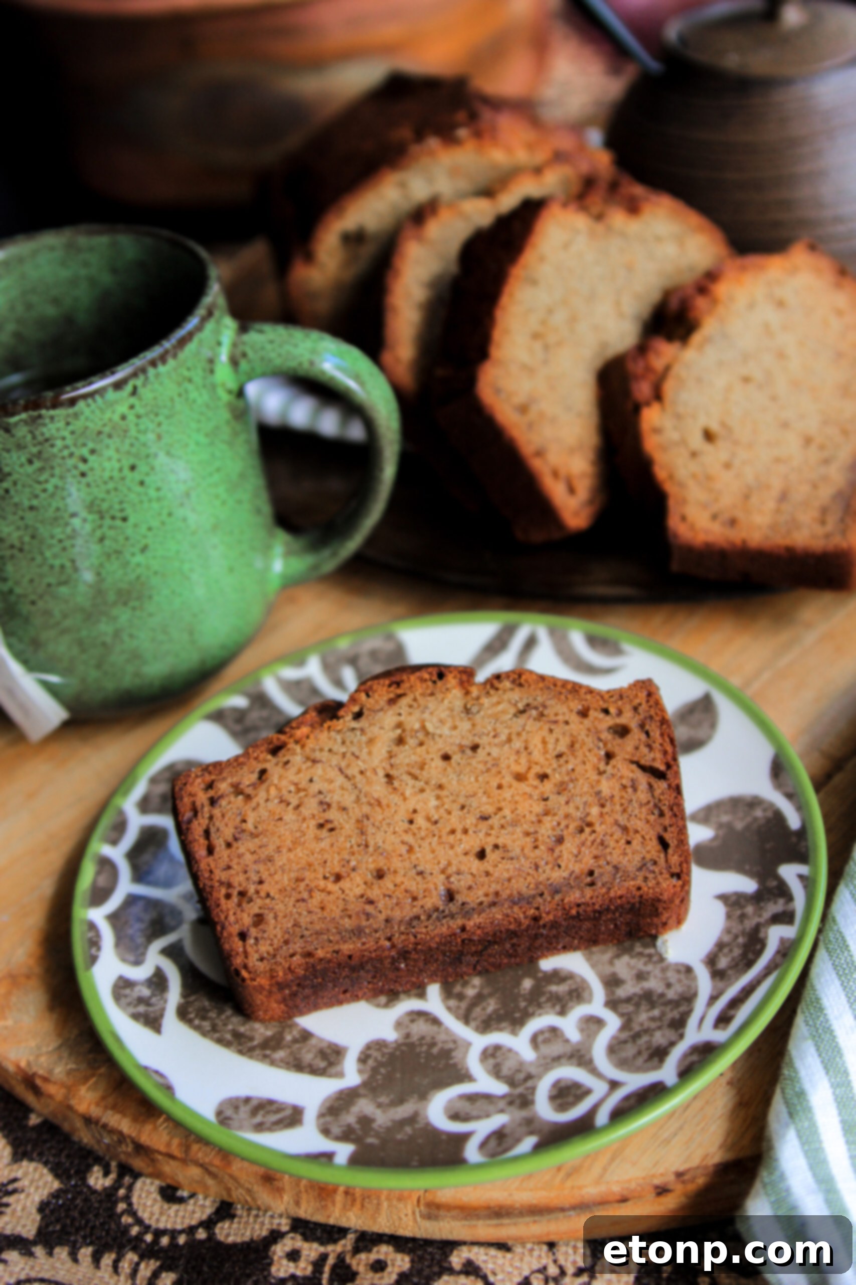 A rustic presentation of banana bread slices with fresh banana pieces and cinnamon sticks, evoking a cozy feel.