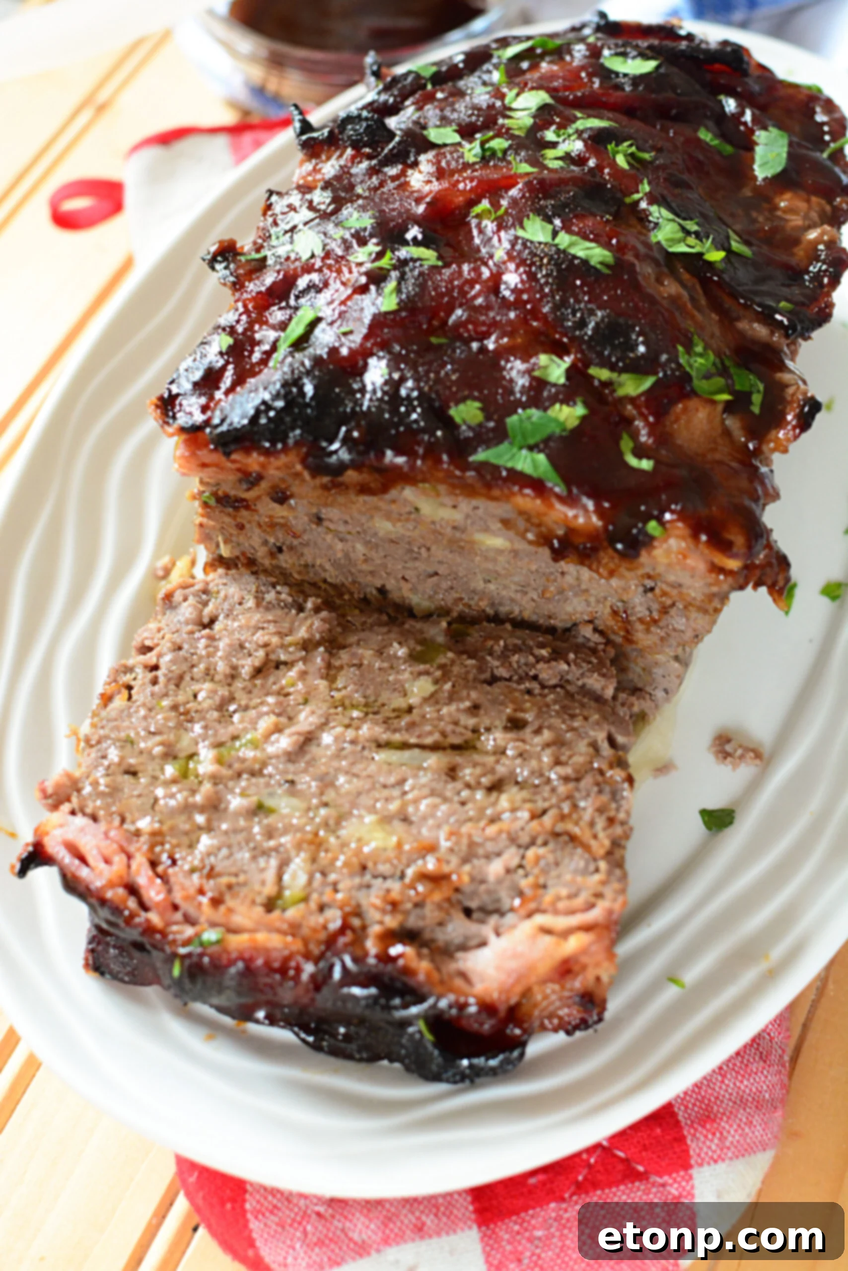Caramelized Bacon Meatloaf 5 Close-up of a slice of candied bacon wrapped meatloaf, highlighting the crispy bacon.