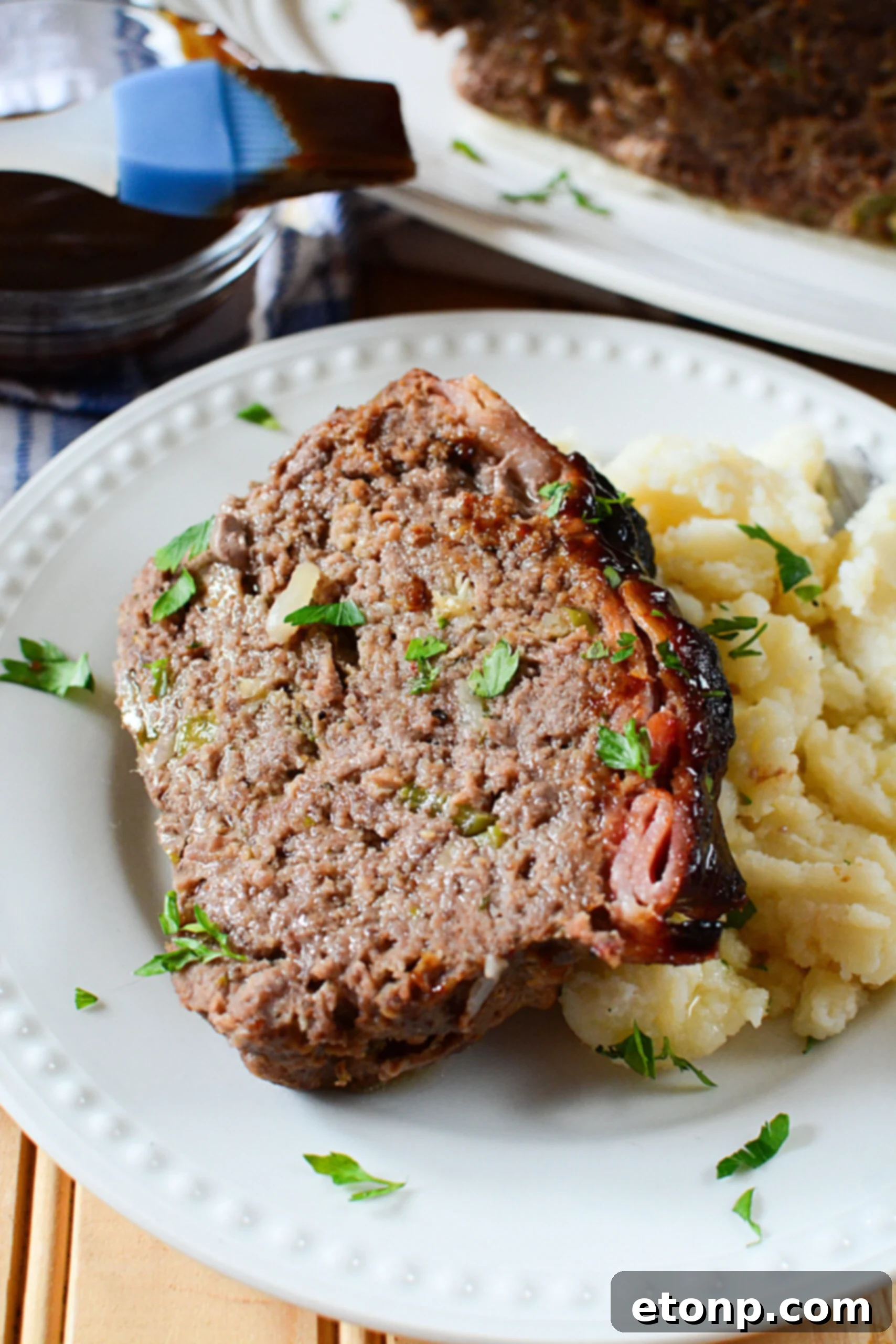 Caramelized Bacon Meatloaf 9 A serving of sliced candied bacon wrapped meatloaf, showcasing the delicious candied bacon.