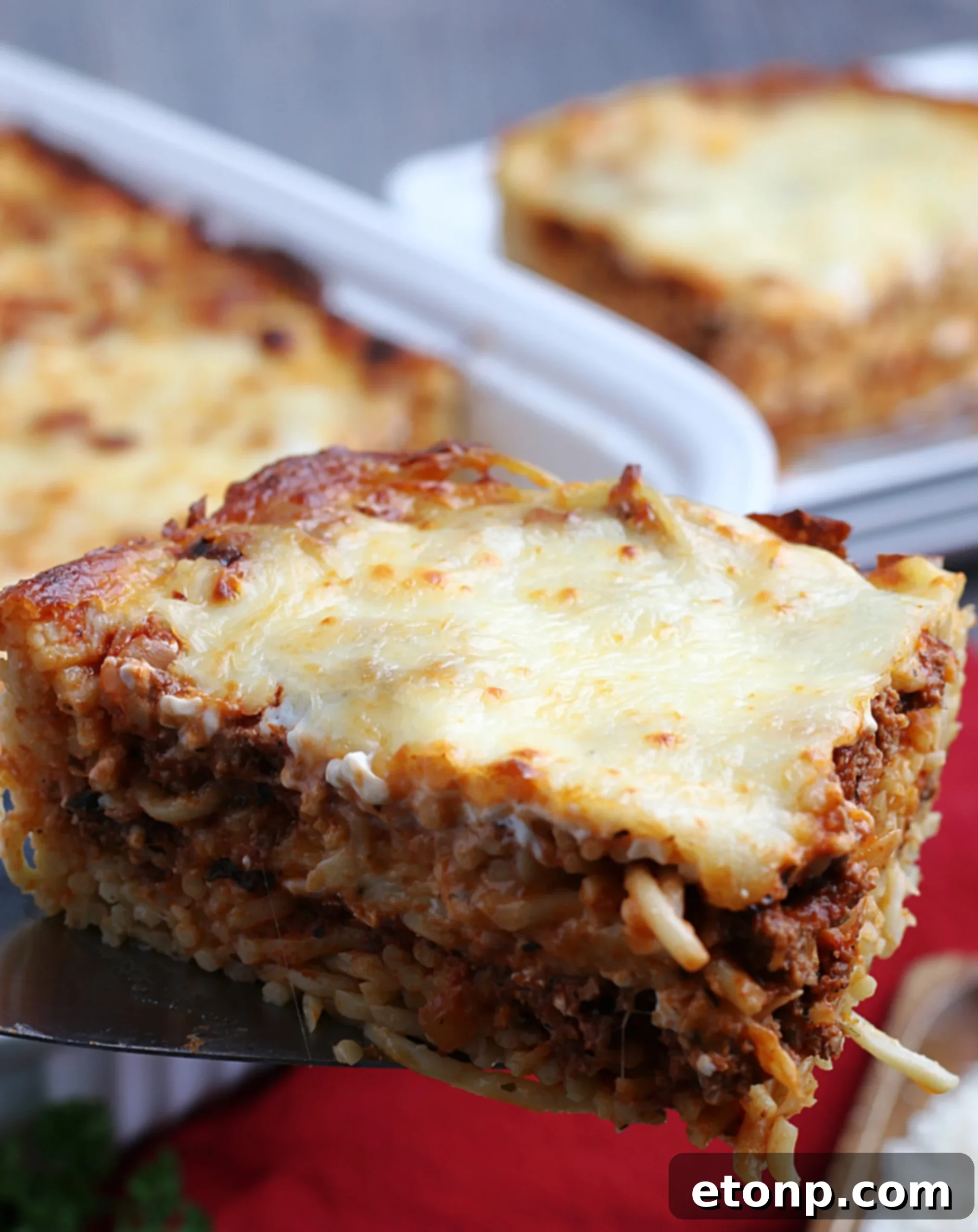 Rich Beef and Melted Cheese Baked Spaghetti 3 Close-up of baked spaghetti layers with melted cheese and beef
