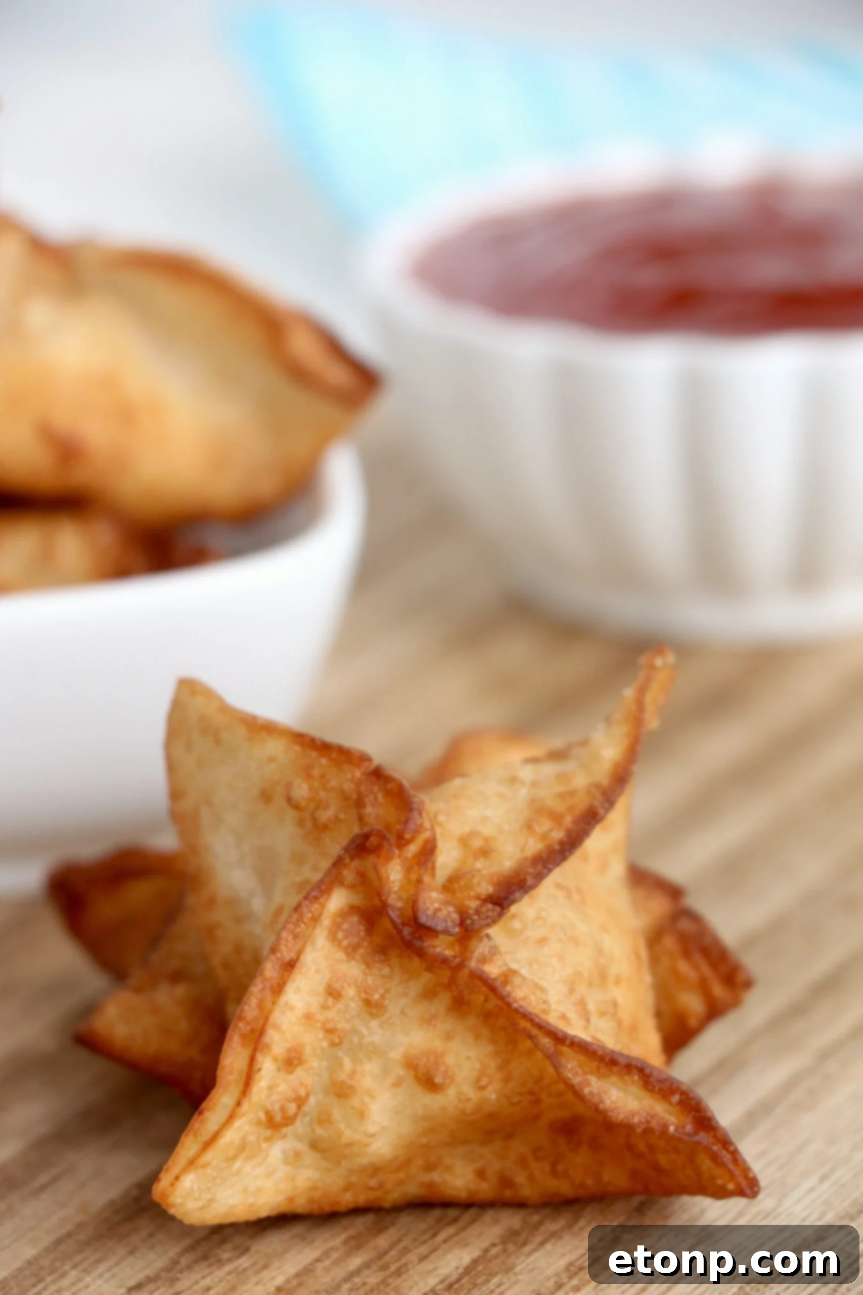 Crispy Cream Cheese Crab Bites 4 A plate overflowing with golden, crispy crab rangoons