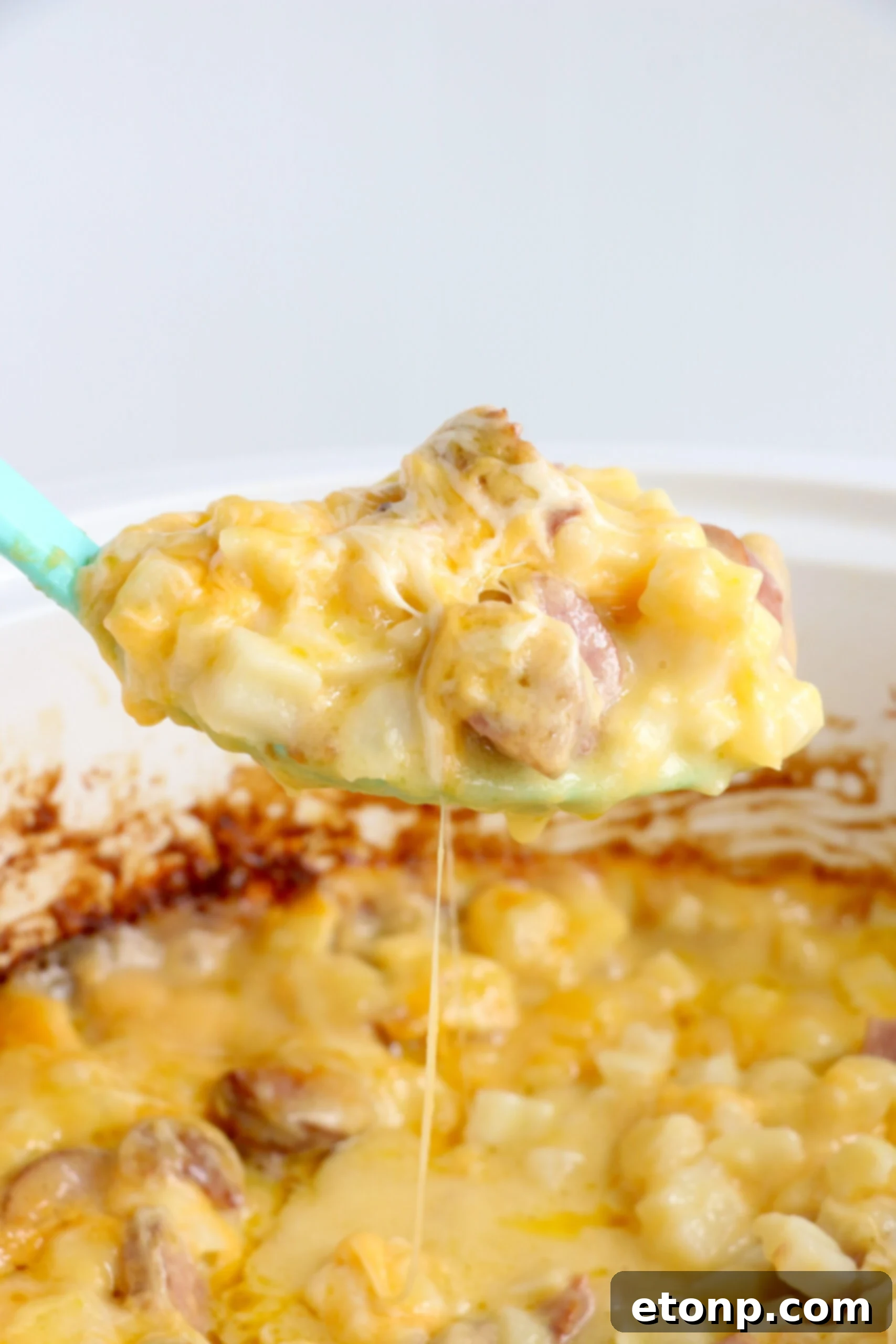 A wide shot of the Slow Cooker Cheesy Kielbasa Hashbrown Casserole bubbling gently in the Crock-Pot, with steam gently rising, highlighting its rich, inviting appearance.
