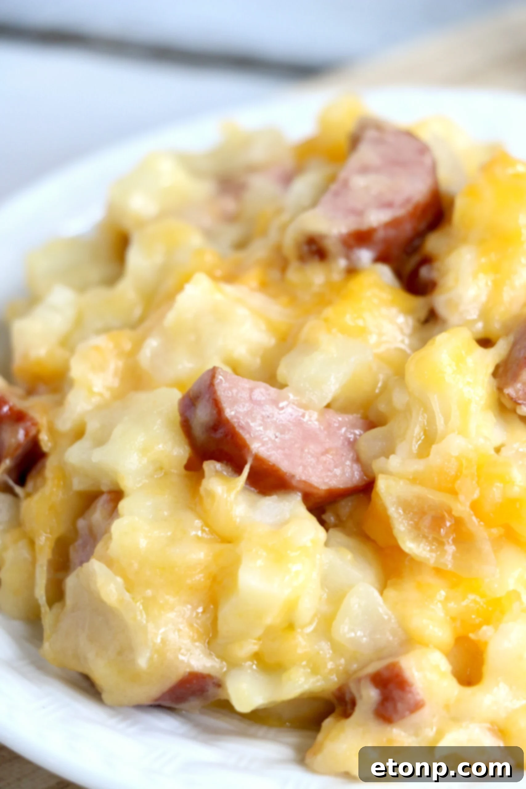Another appealing perspective of the Cheesy Kielbasa Hashbrown Casserole, showcasing its rich, creamy consistency, chunky pieces of kielbasa, and the inviting golden-brown crust.