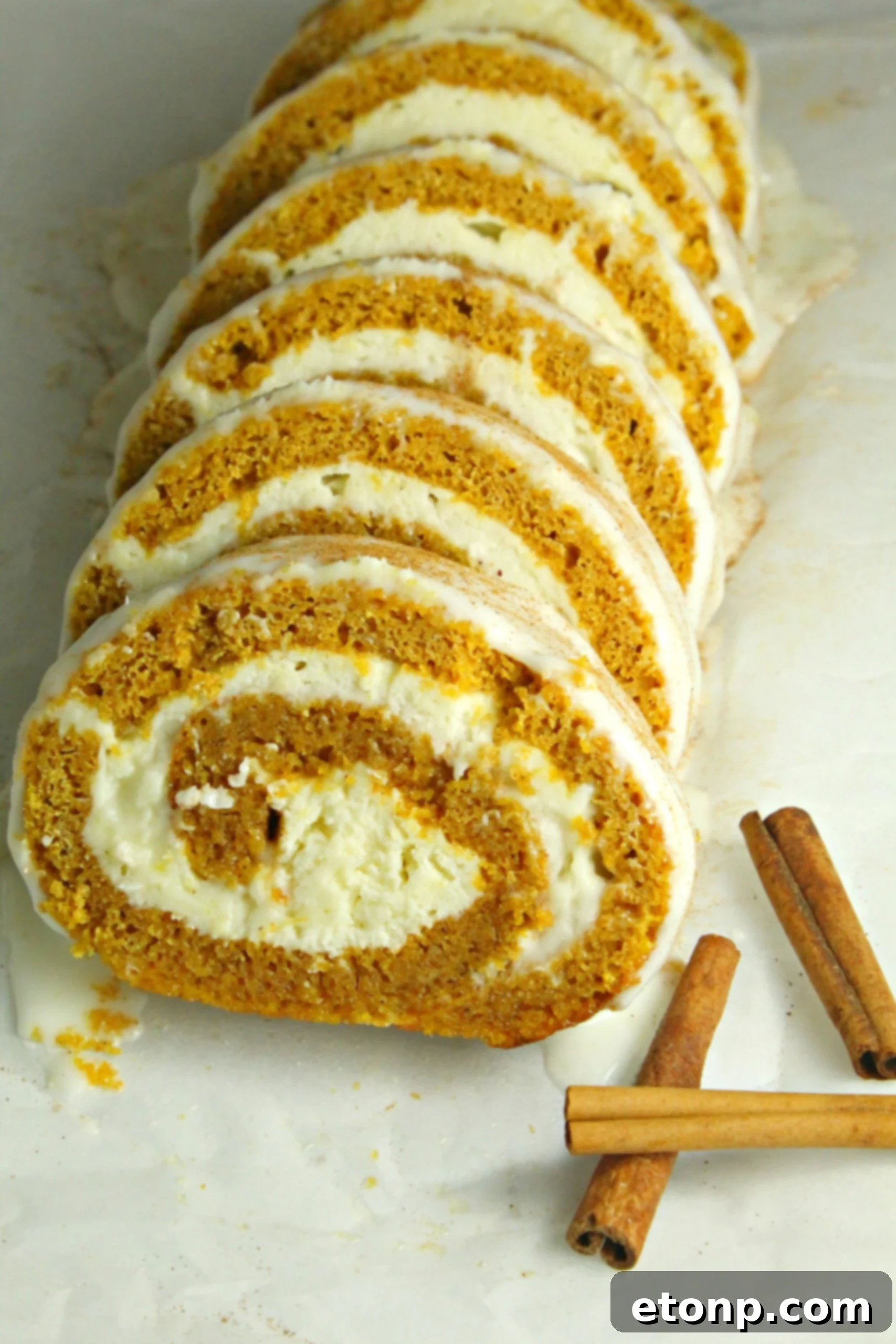 A chef's knife slicing a pumpkin roll, demonstrating the technique for clean cuts.