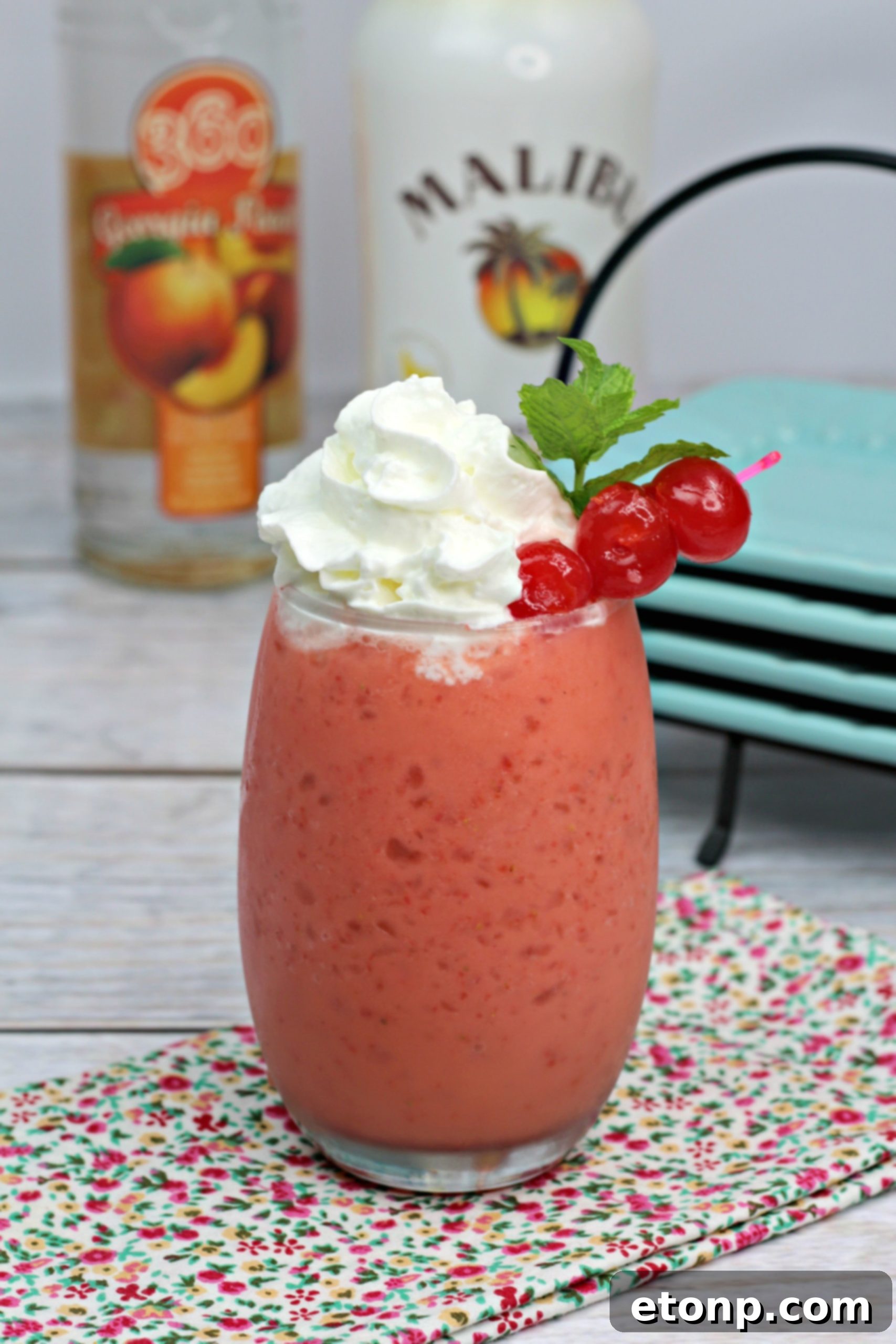 Closeup of a Pink Panties Cocktail showing its creamy texture and vibrant pink color, garnished with whipped cream