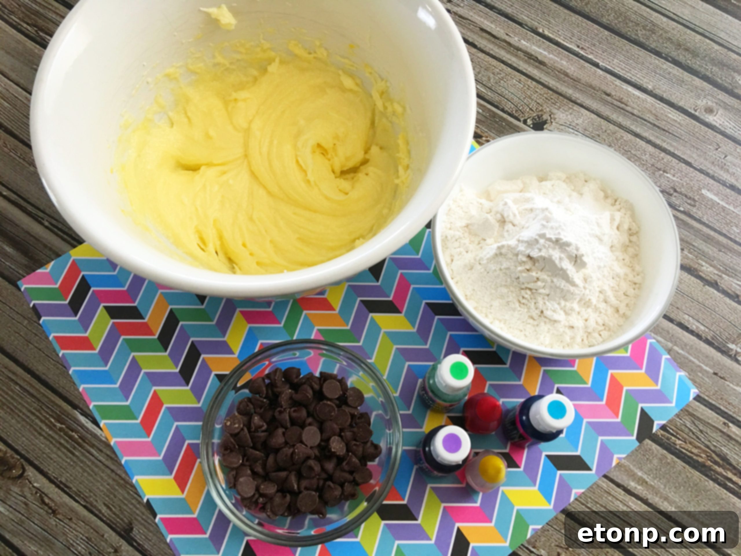 Freshly baked rainbow chocolate chip cookies cooling on a wire rack, showcasing their colorful centers and golden edges