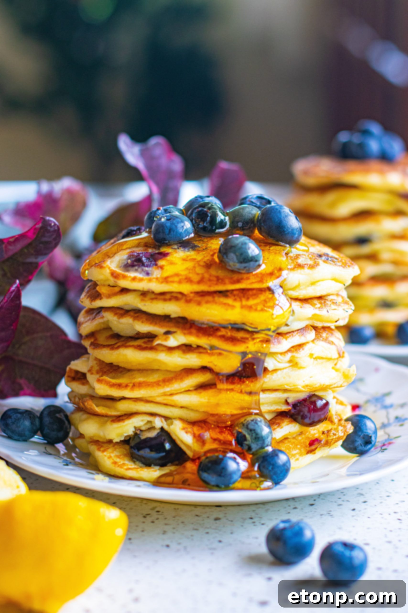 Side view of a stack of golden blueberry cream cheese pancakes