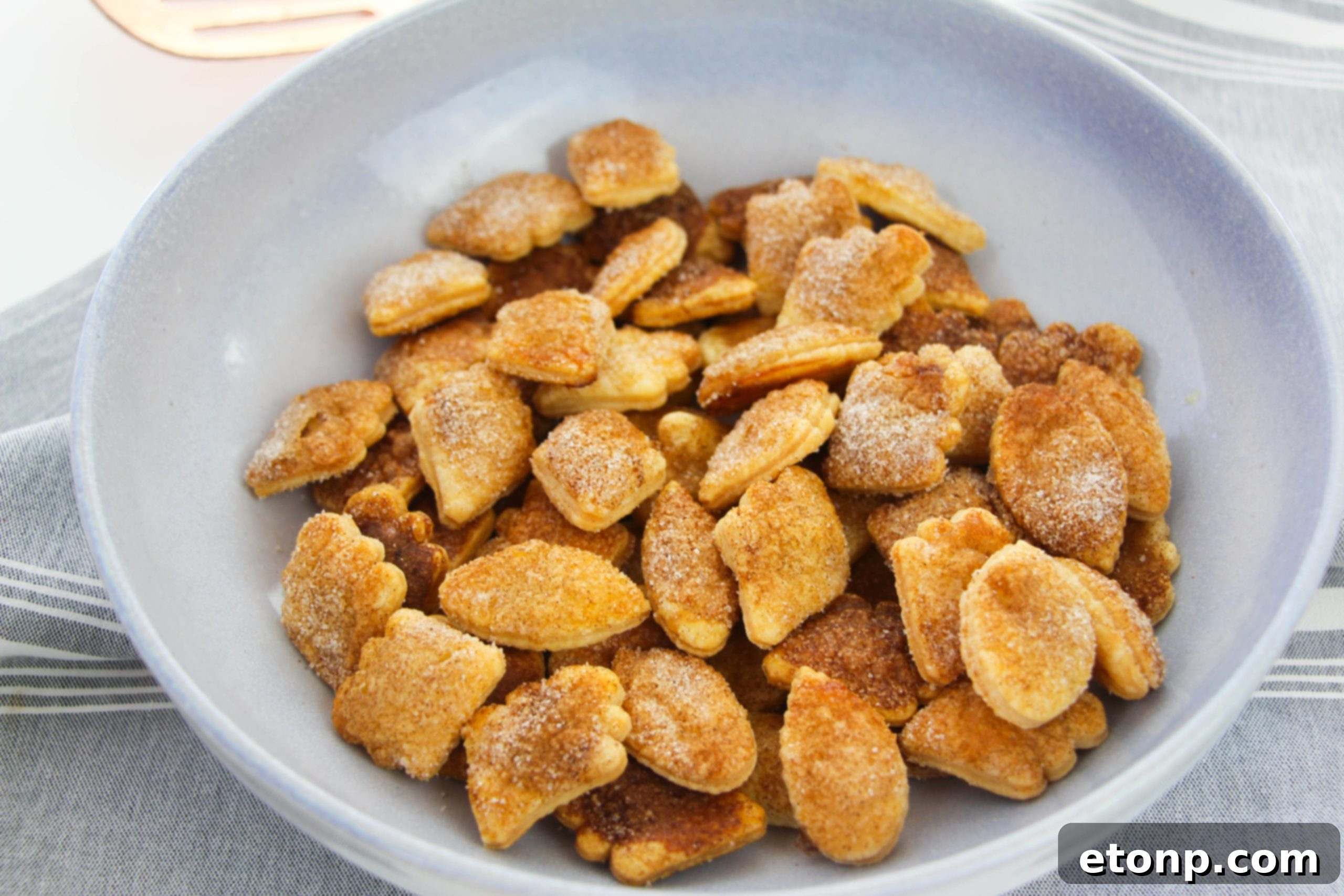 Snickerdoodle Pie Crust Cookies shaped like autumn leaves, beautifully arranged on a white tray, ready for baking