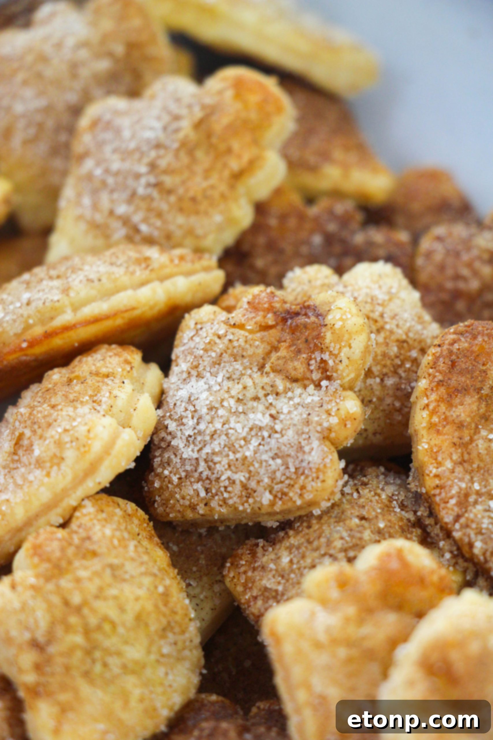 Snickerdoodle Pie Crust Cookies on a cutting board, ready to be enjoyed, with a few crumbs scattered around