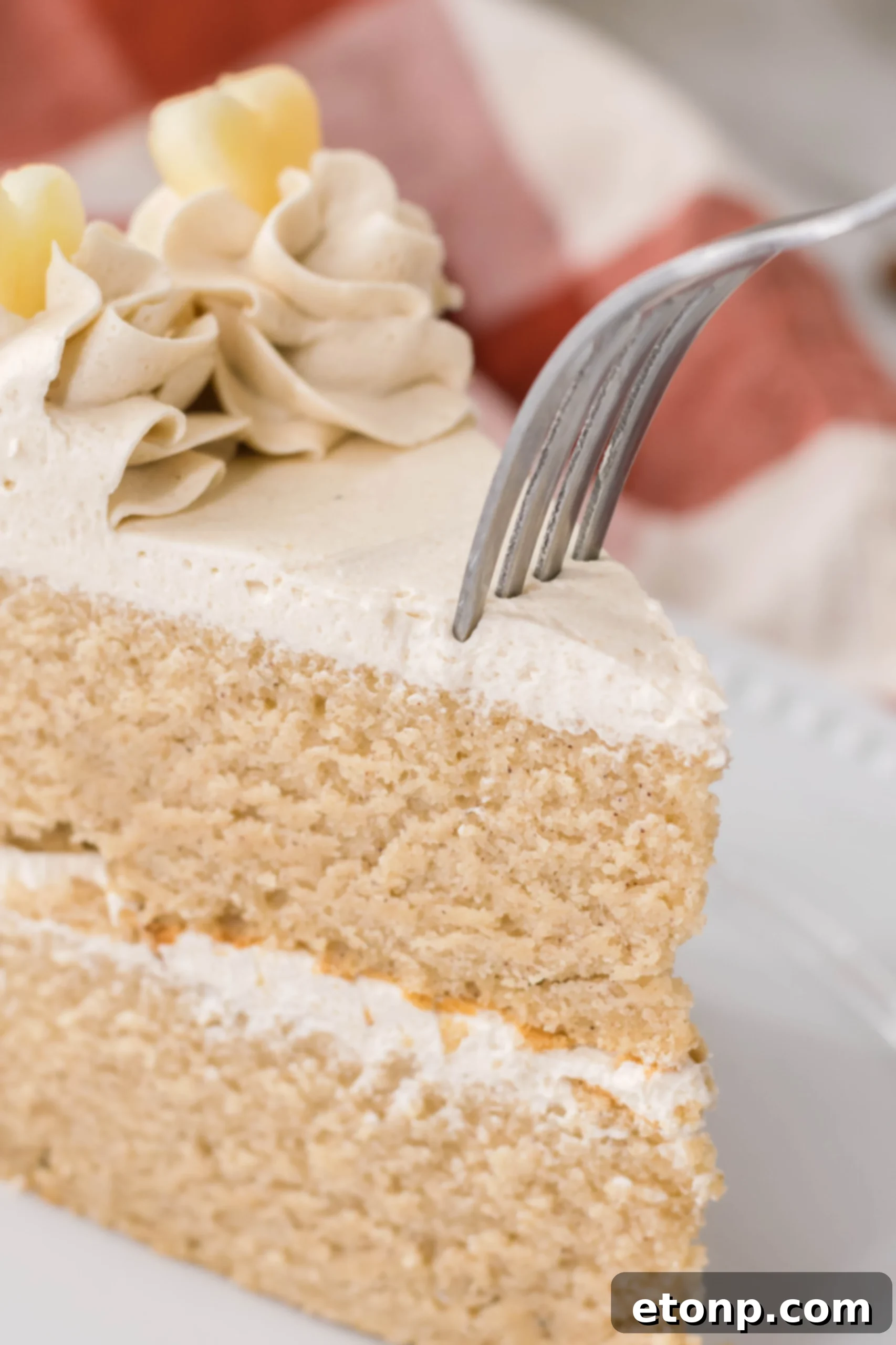 Side view of the apple cider cake, showcasing its layers and generous frosting