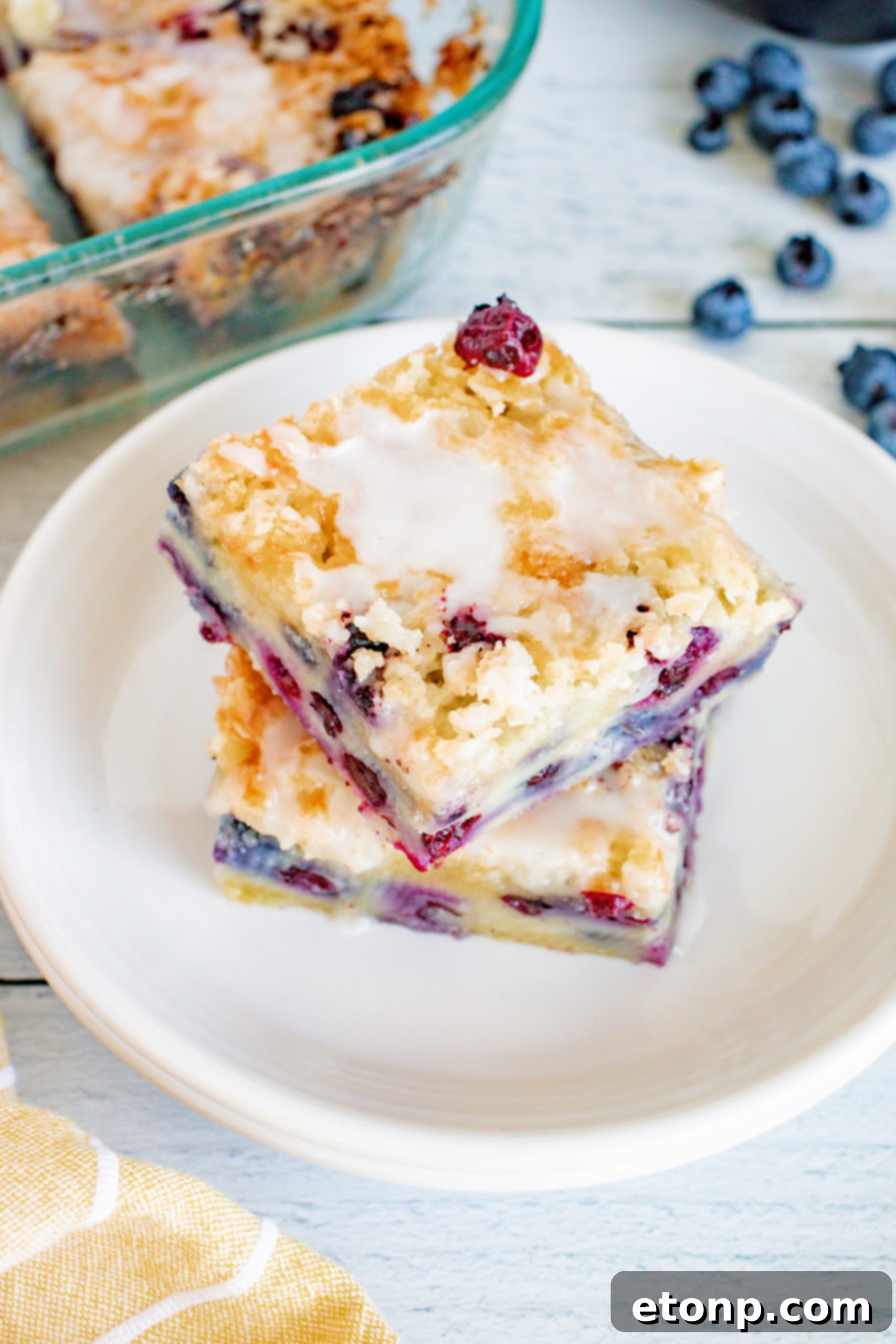 The blueberry muffin cake cooling on a wire rack, showing its perfect golden crust and glaze