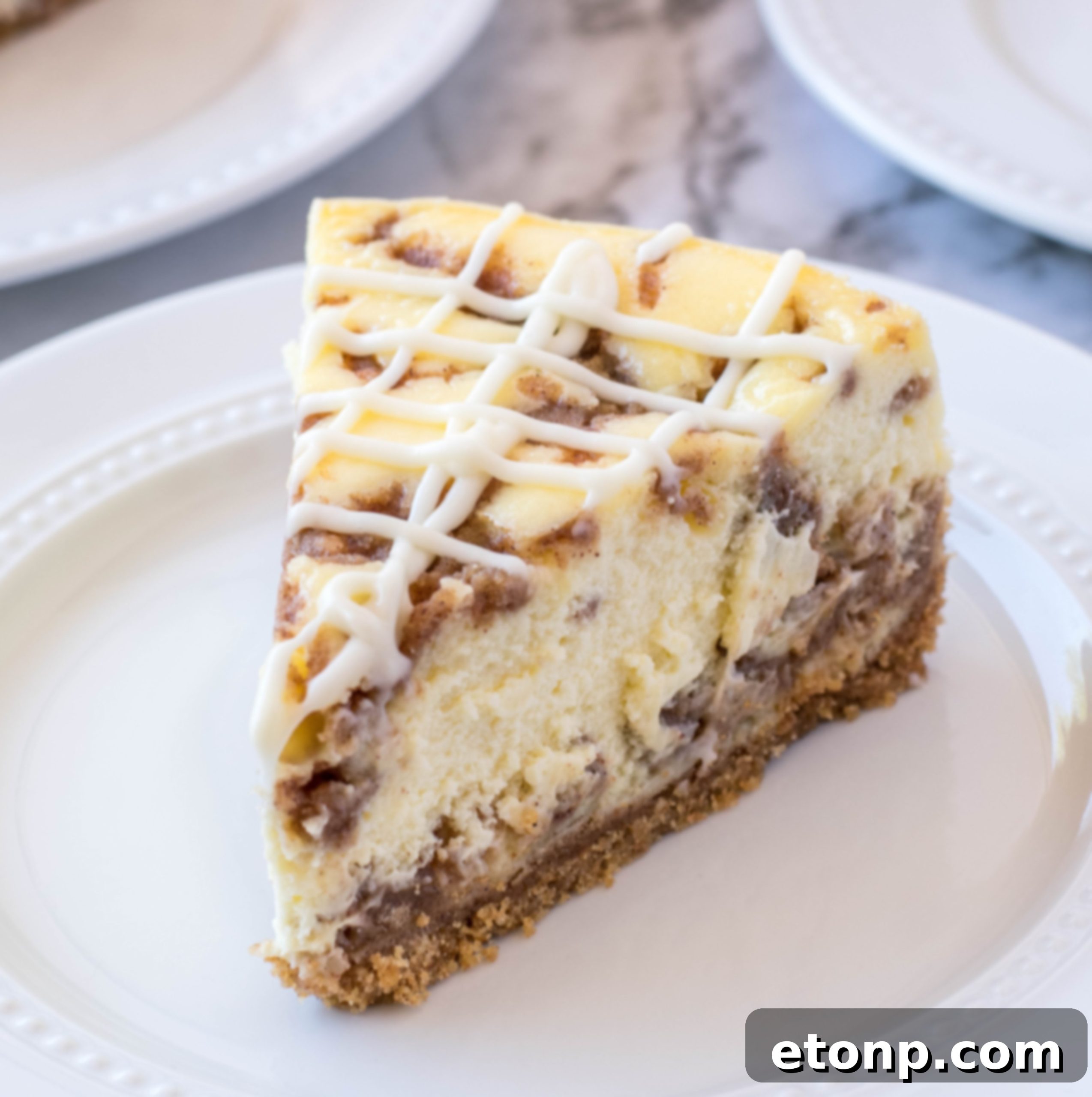 A close-up shot of a Cinnamon Roll Cheesecake slice on a fork, highlighting its creamy texture and delicious layers.