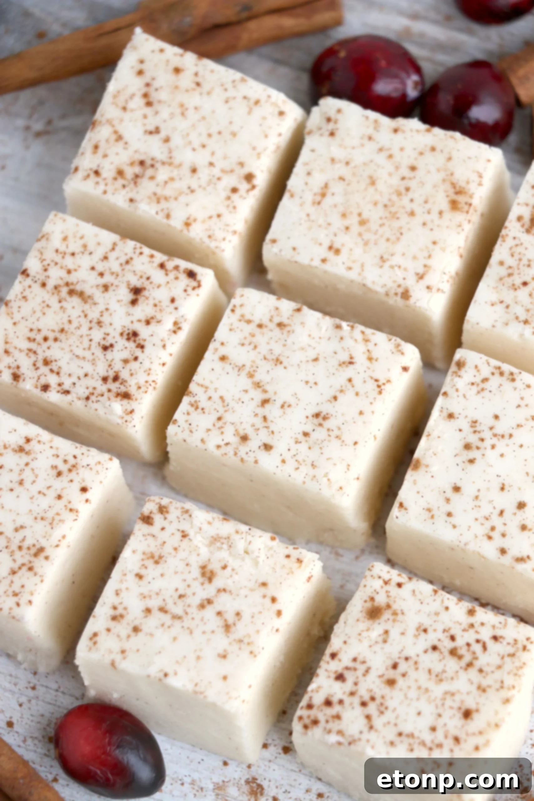 Stack of creamy eggnog fudge squares, showing the smooth, soft texture.