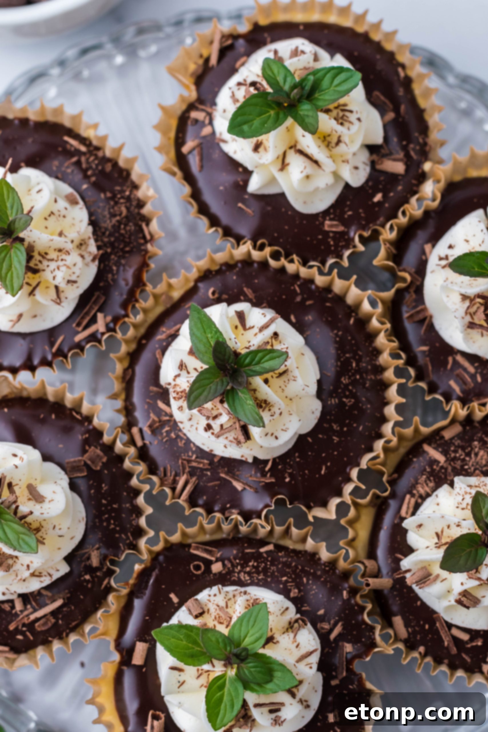 A mini cheesecake being drizzled with chocolate ganache