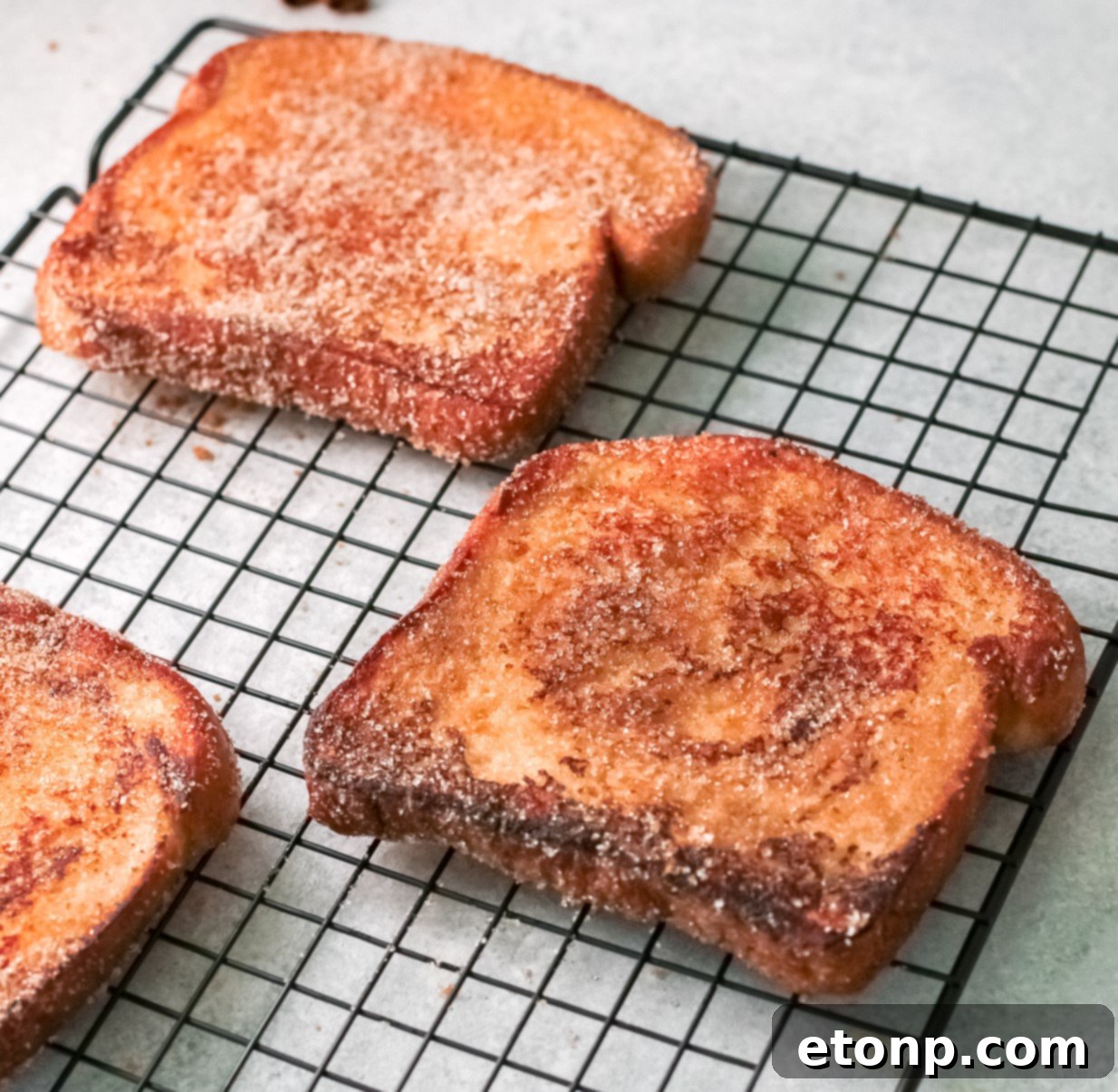 Close-up of Churro Cinnamon Sugar French Toast, showing the crispy texture and generous coating of cinnamon sugar.